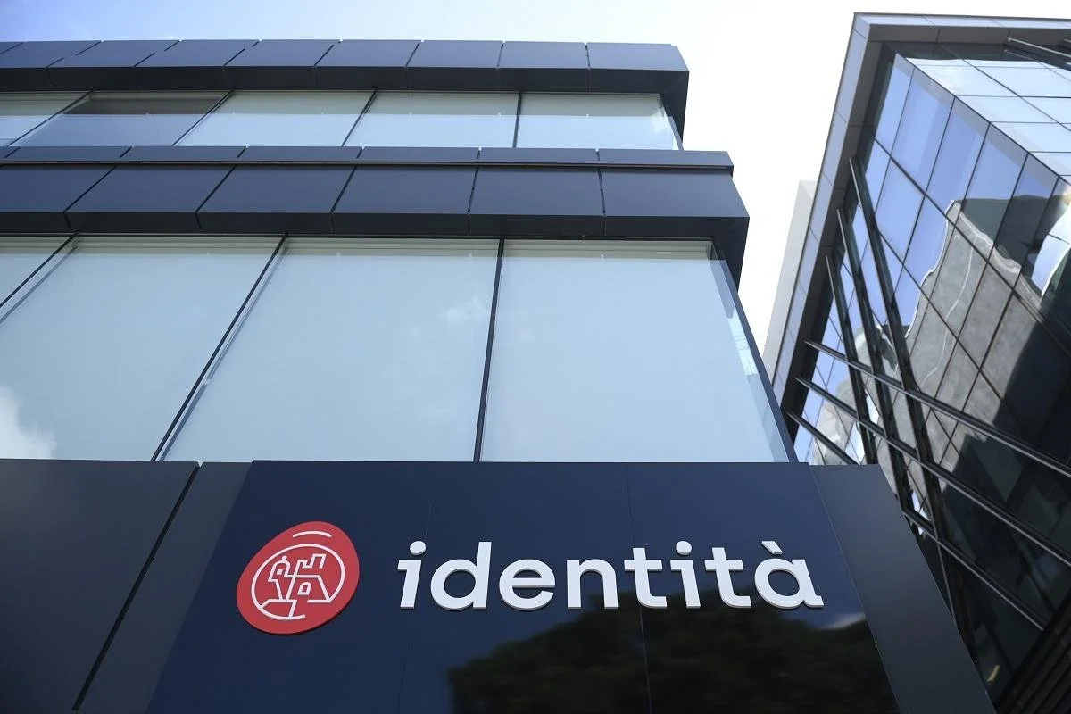 Exterior view of the Identità agency office building in Malta, displaying the large illuminated logo and signage on a dark facade.
