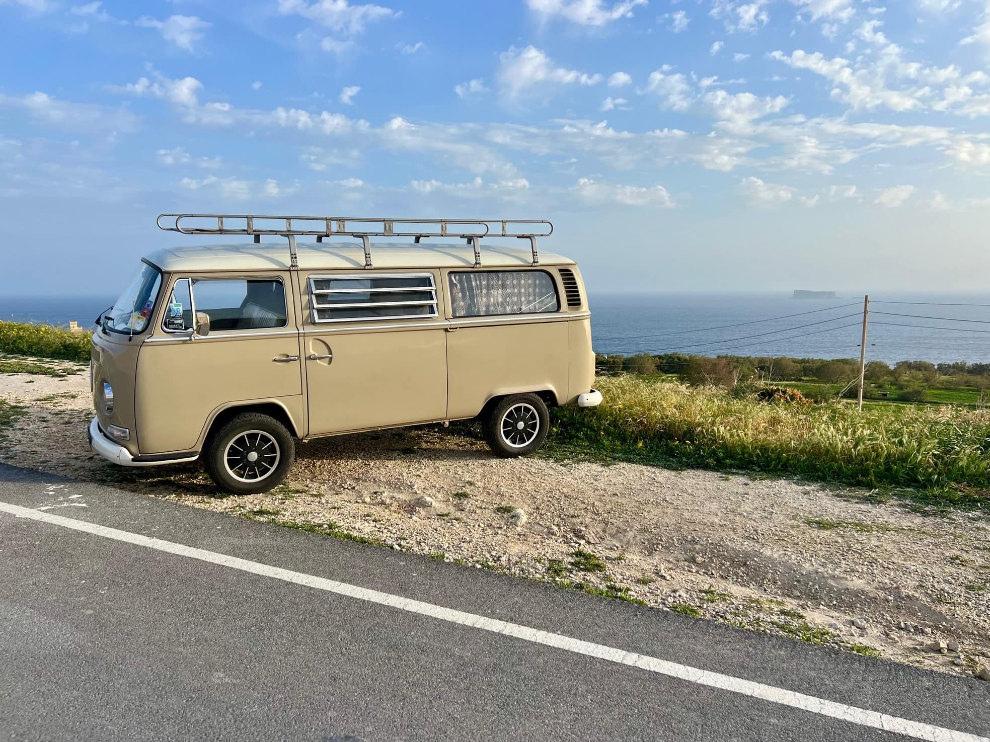Camper parked along the road with Filfla Island in the background.