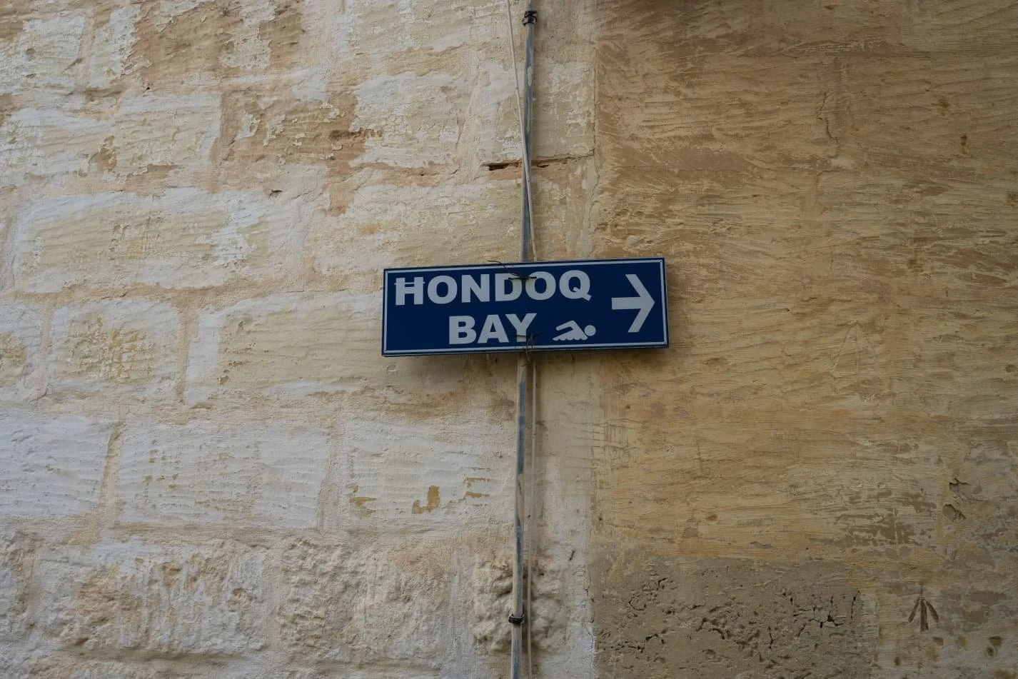 Hondoq Bay directions indication fixed at limestone wall.