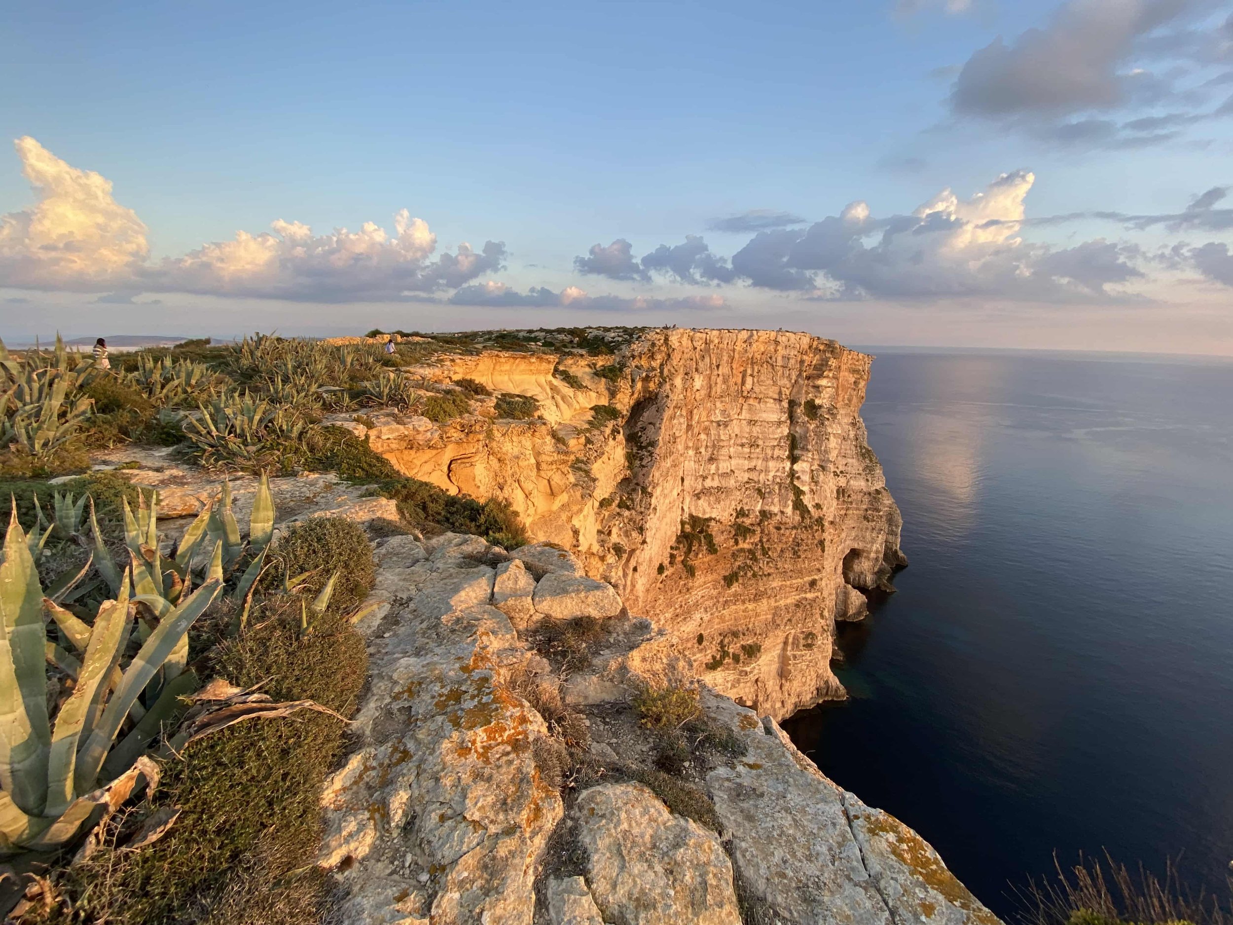 Panoramic view of the limestone cliffs shining in light orange at late sunset hour.