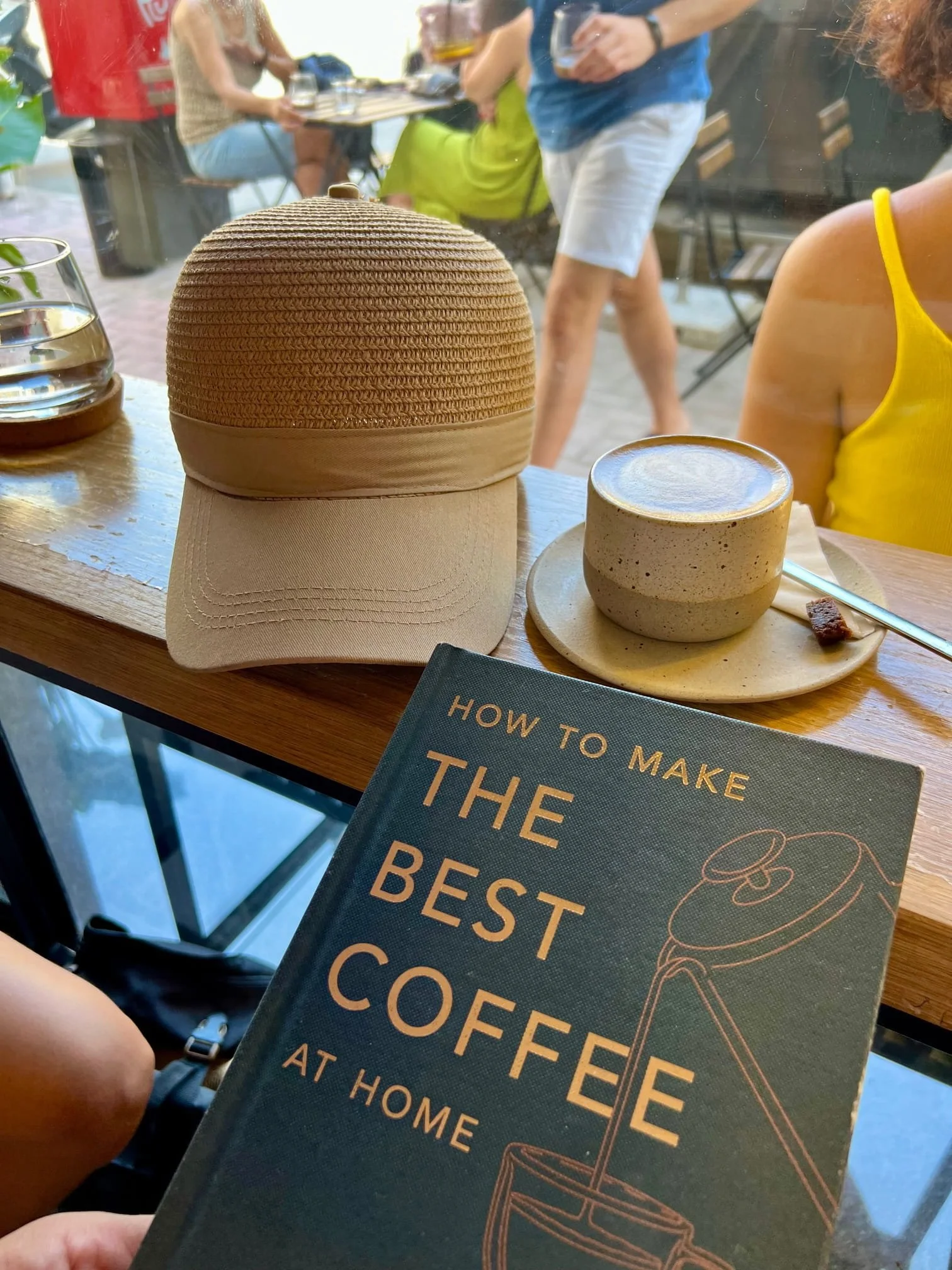 A cappuccino, a straw hat and a magazine titled "The Best Coffee at Home" sitting on a window ledge at Loaf Café, Gzira.
