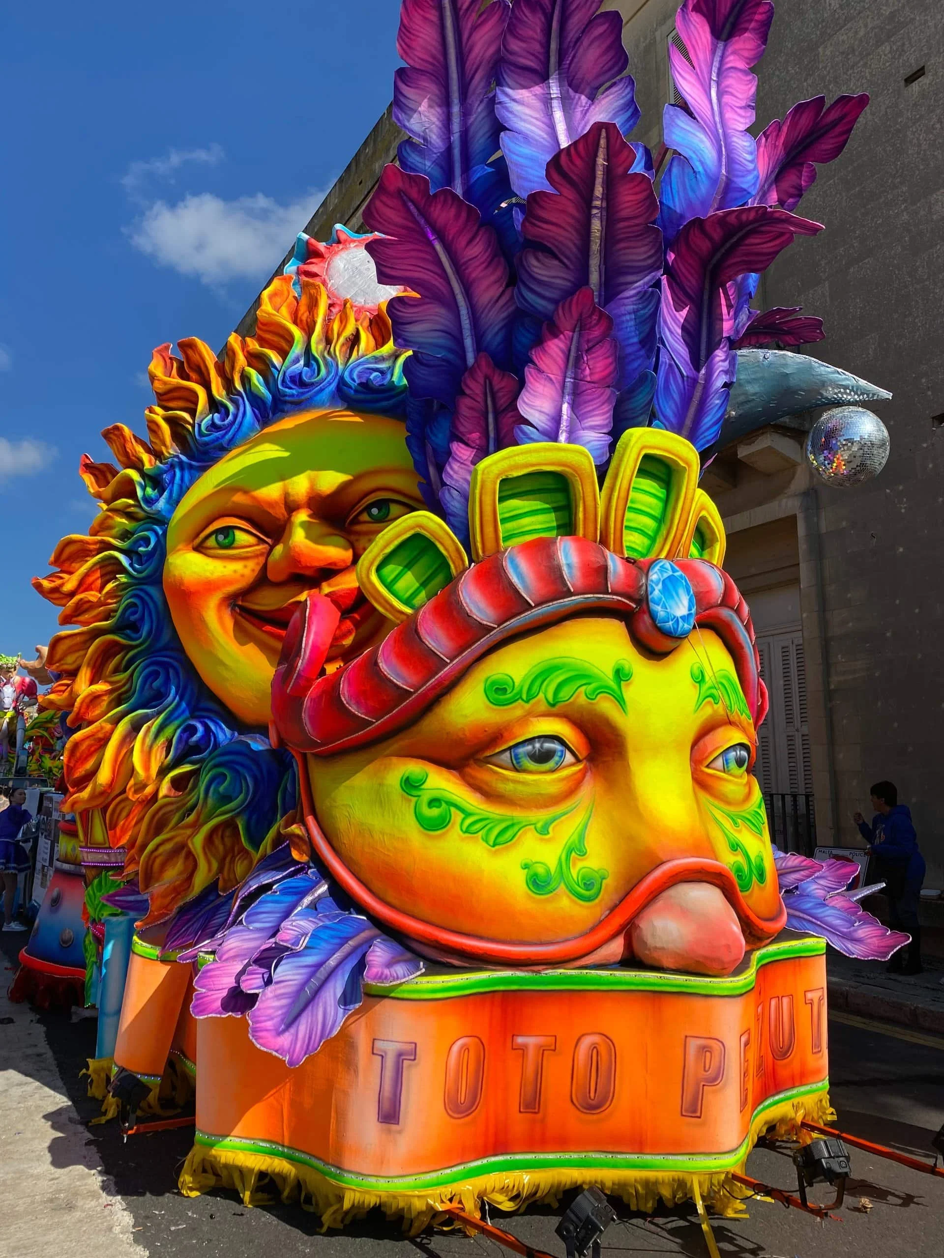 Colorful neon carnival float with mask face close up.