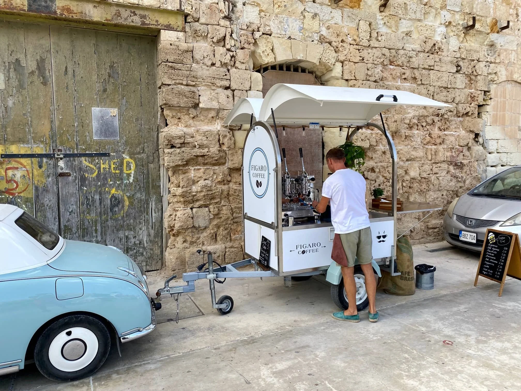A mobile coffee wagon serving customers on the historic limestone waterfront of Senglea.