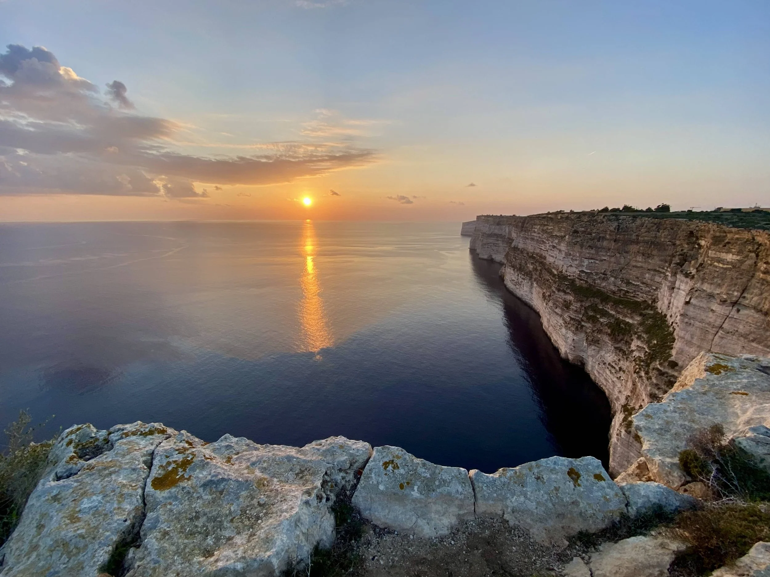 The sun setting over the horizon at Ta' Cenc Cliffs.