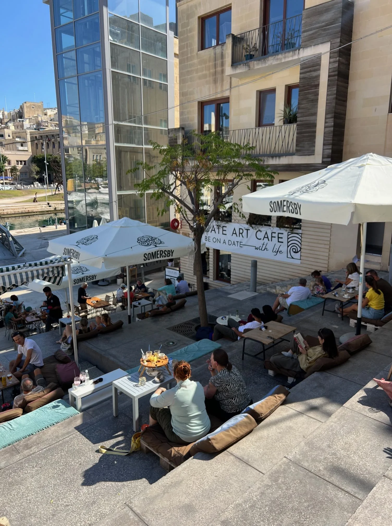 Relaxed seating on pillows and pallets on the stairs at DATE Art Café overlooking the marina.
