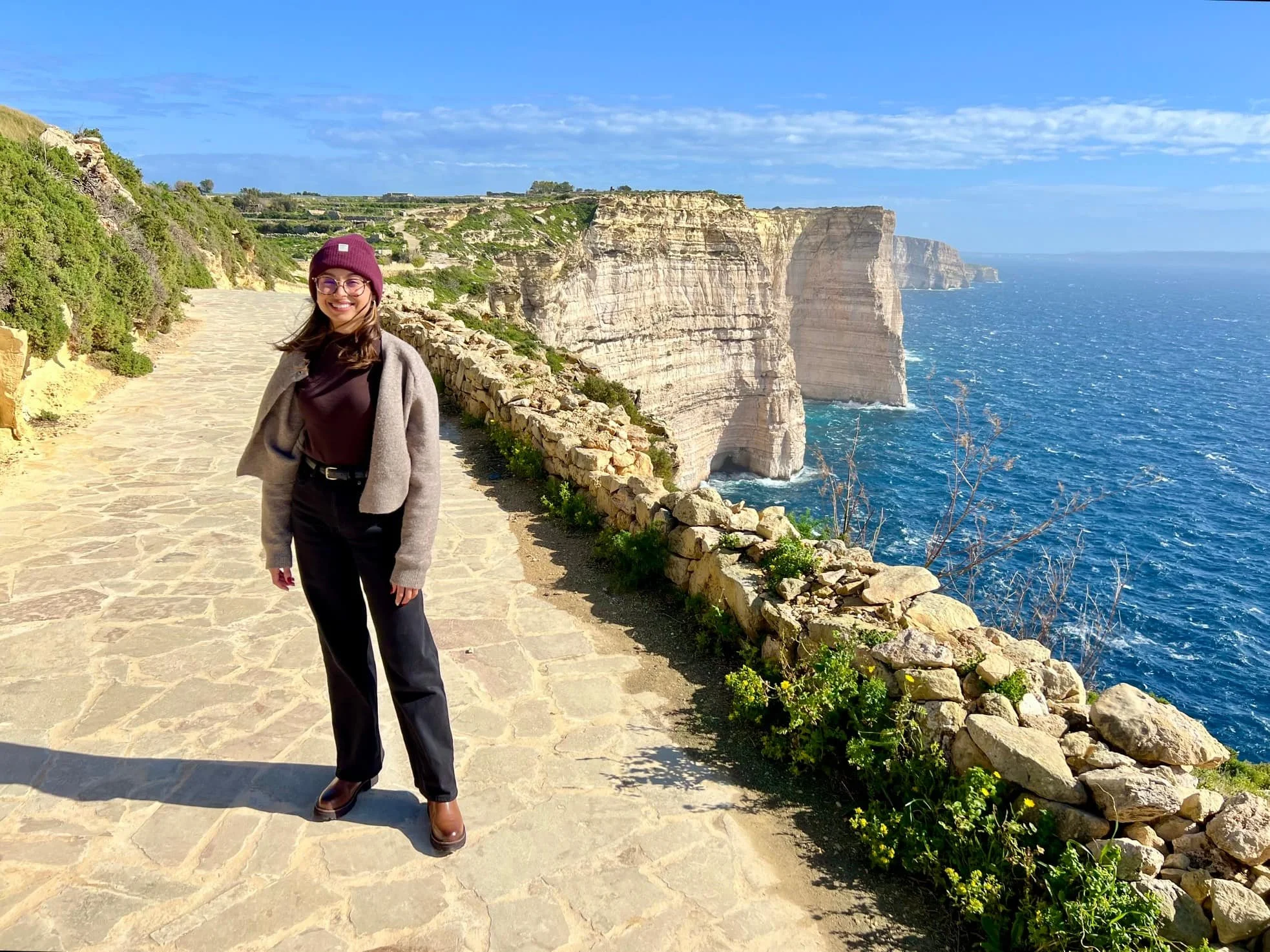 Woman standing on the walking path that connects Sanap Cliffs with Xlendi.