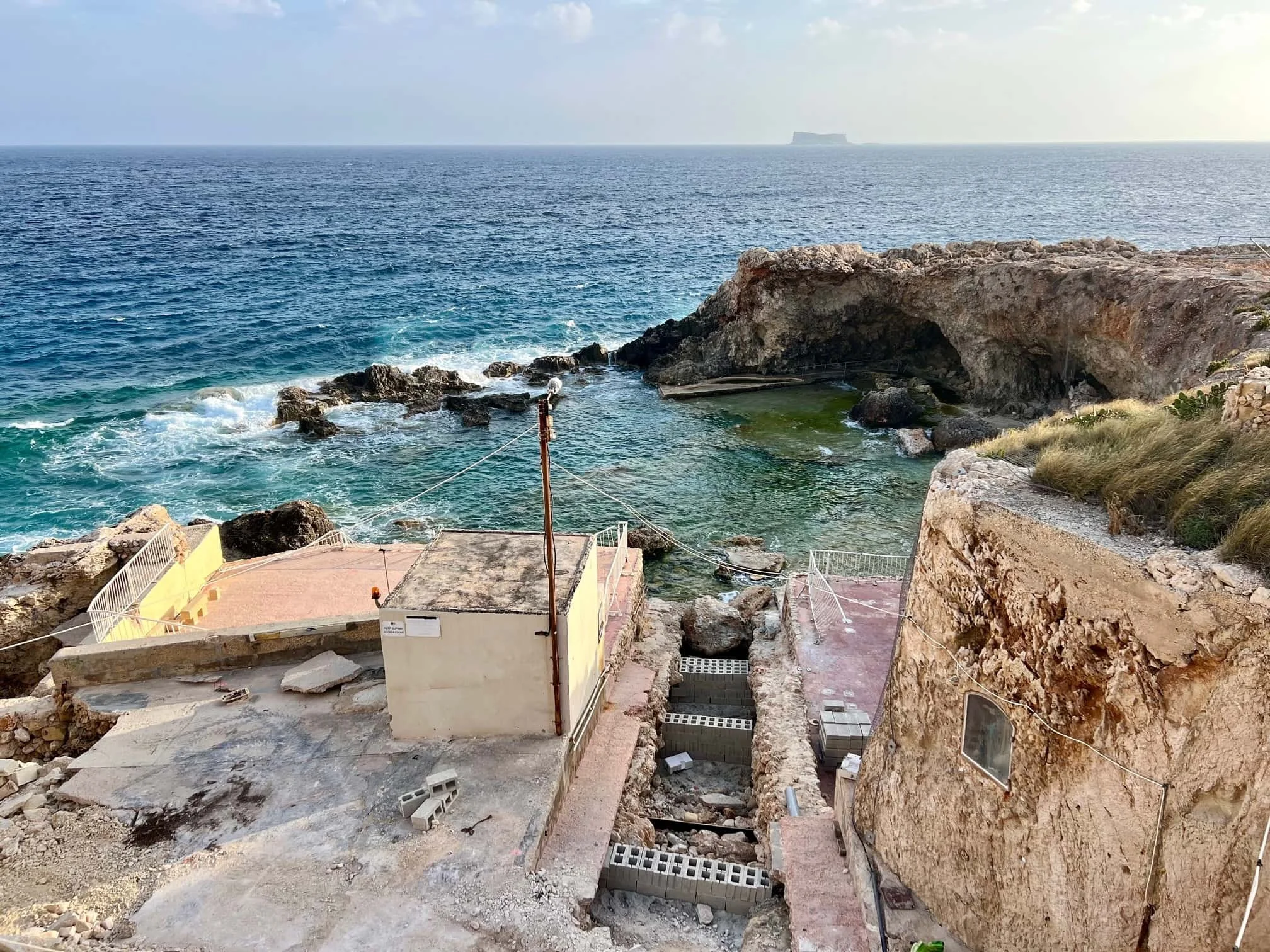 The natural rocky pool at Ghar Lapsi with access path damaged by Storm Harry.