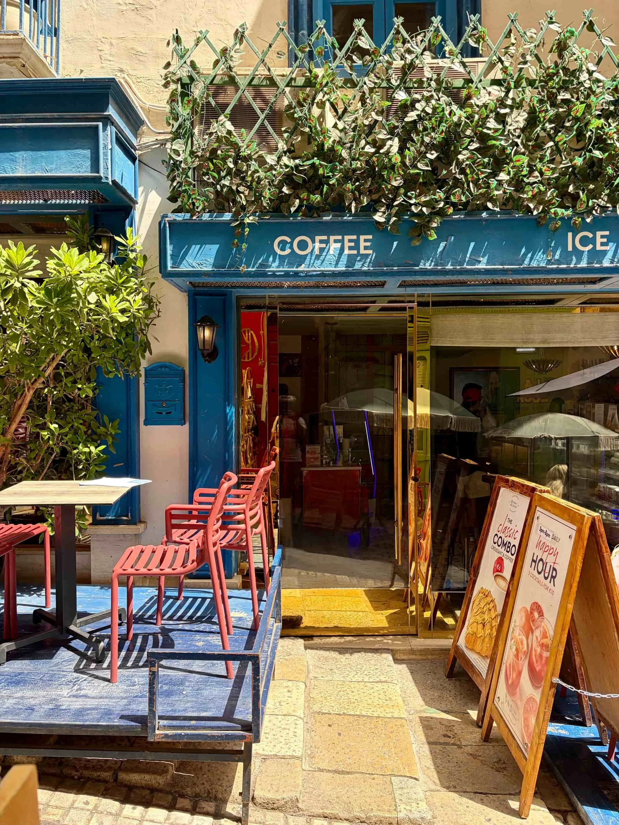 Distinctive blue storefront exterior and outdoor seating of Sunday in Scotland, Valletta.