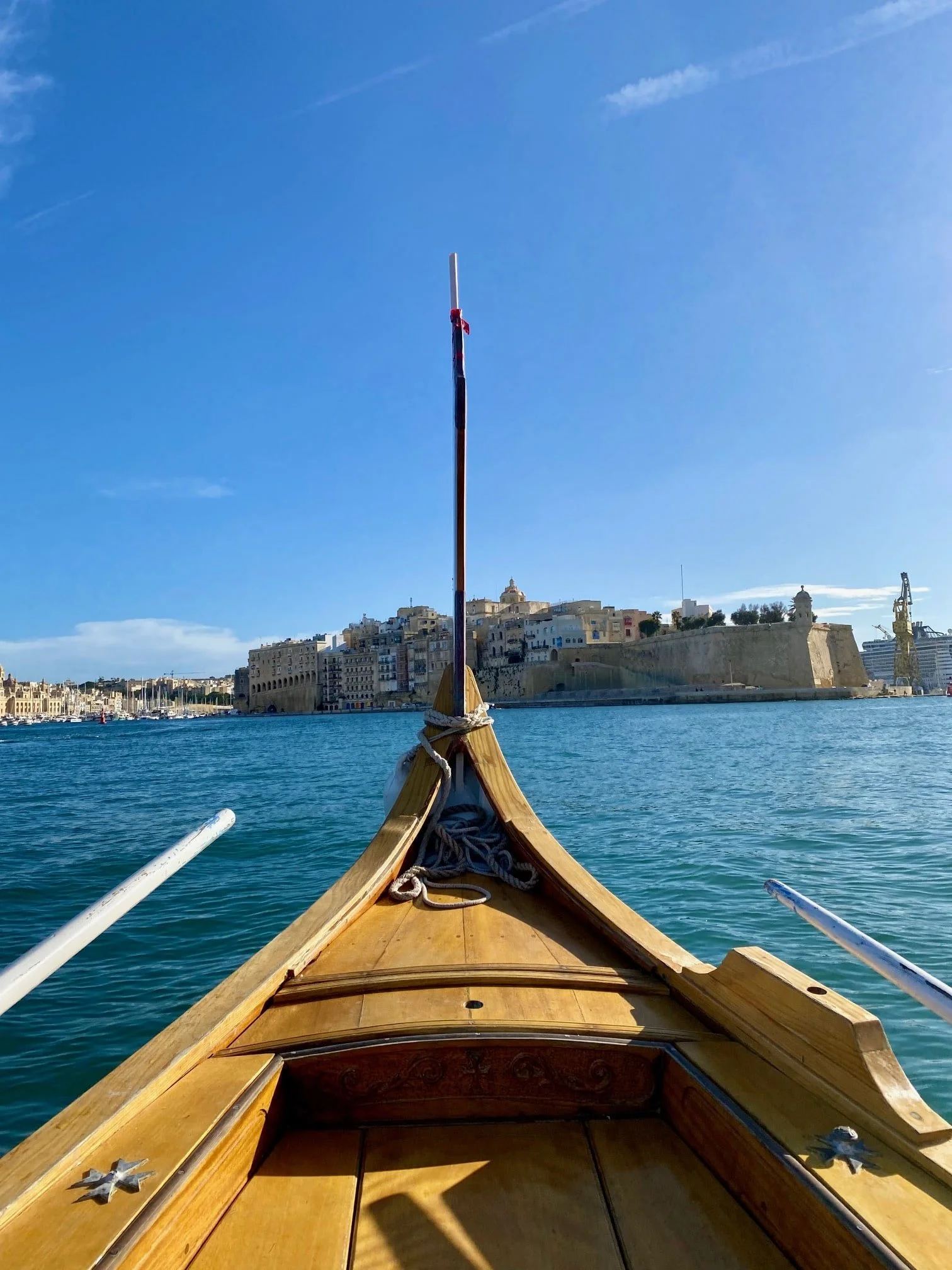 A view of the Senglea peninsula fortifications seen from a traditional Luzzu boat in the harbour.