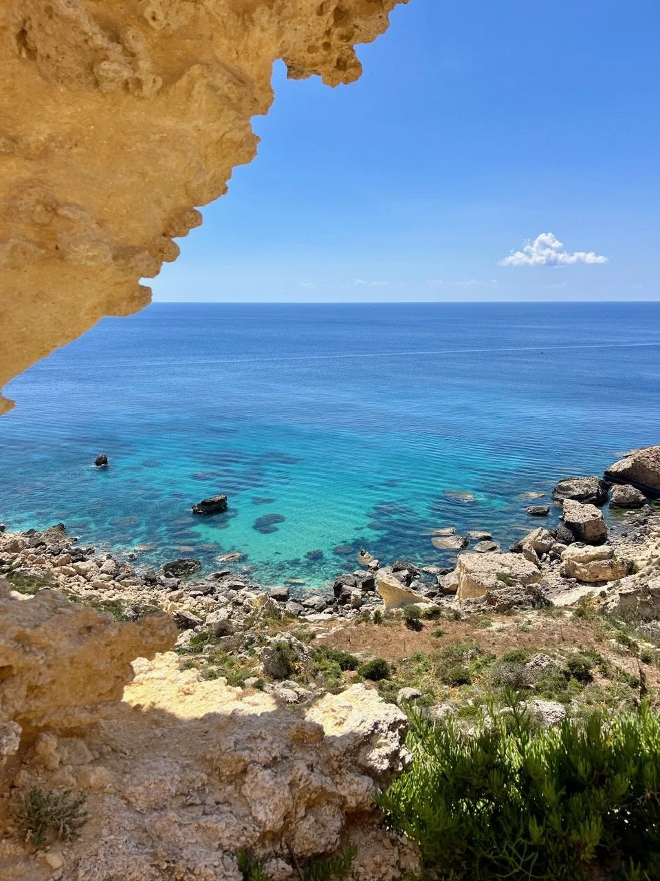 View through an eroded limestone rock opening near Ras il-Wahx overlooking the sea.