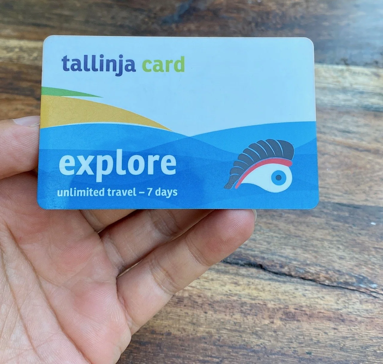 A hand holding the Tallinja Explore Card (7 days unlimited travel).