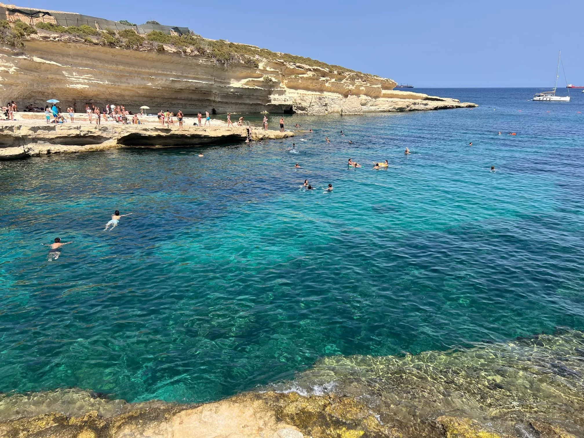 The crystal clear turquoise water of Il-Kalanka Bay, perfect for snorkeling and swimming.