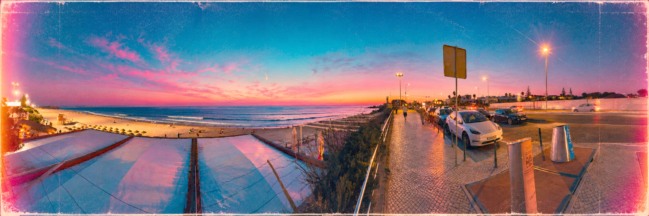 Sunset view over a beach with colorful sky, ocean waves, sandy shoreline, parked cars, and a pedestrian walking along the sidewalk.