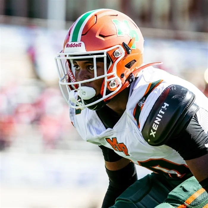 Football player in orange helmet and white jersey on field