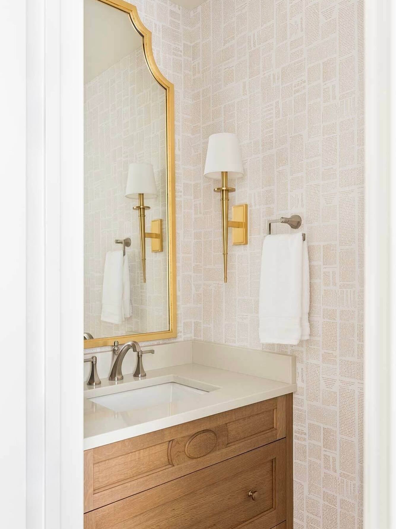 This powder room plays with muted layers, warm brass accents, and a statement newspaper wallcovering from @momentum_textiles_walls that brings just the right amount of fun.

#powderroomdesign #wallcoveringlove #brassdetails #interiorbranding #designd