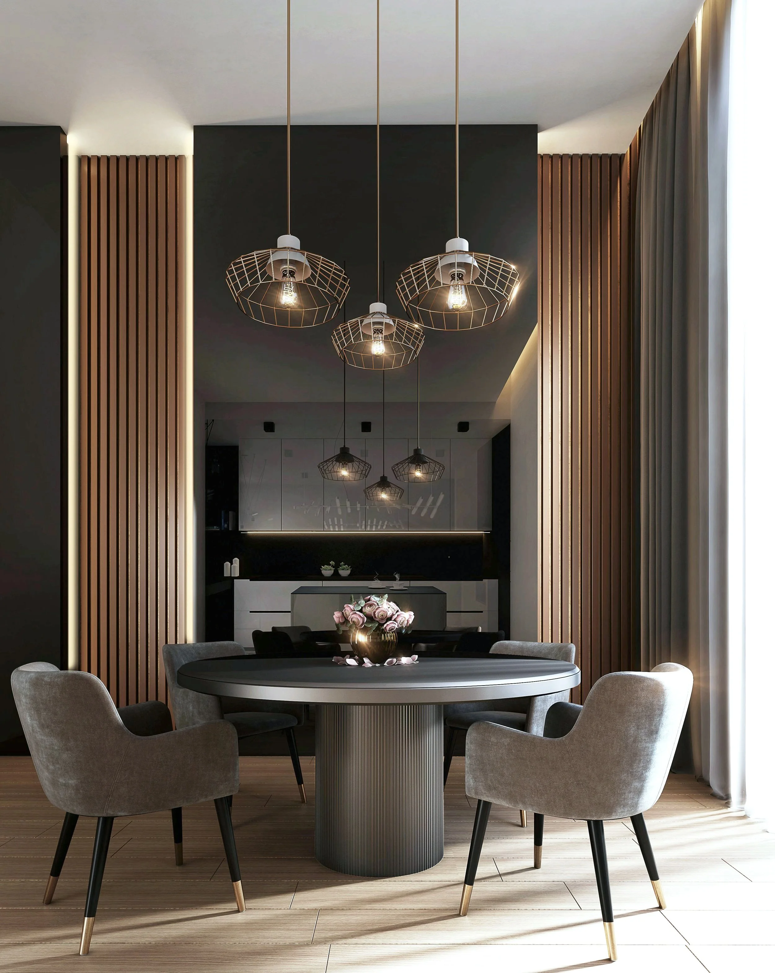 Modern dining room with a round table, six gray upholstered chairs, a black vase with pink roses, black cabinets, and hanging pendant lights with wireframe shades. There are wood panel accents on the walls and a sheer curtain on the right side.