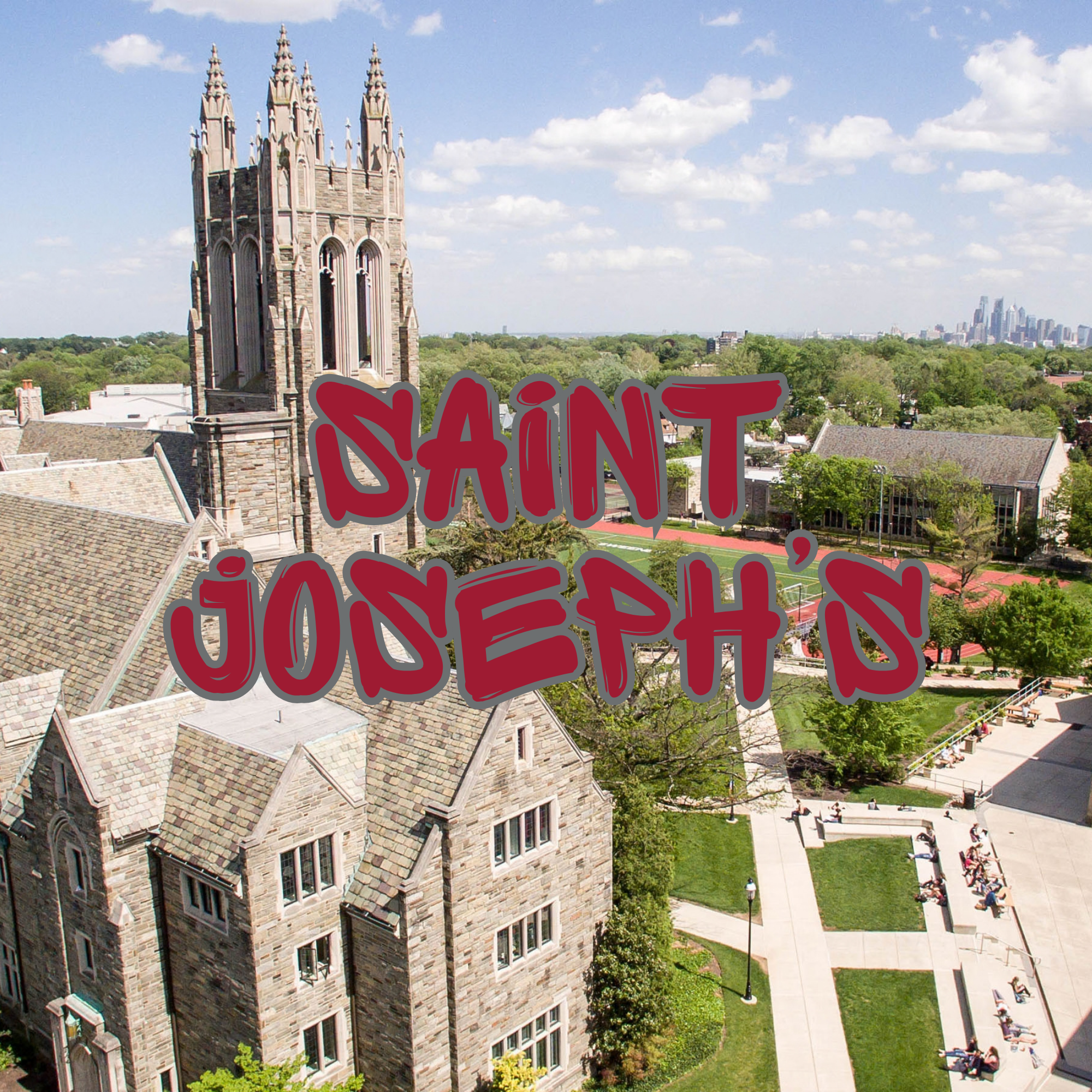 An aerial view of a historic stone building with a tall clock tower, surrounded by trees and a modern city skyline in the background on a sunny day with blue sky and scattered clouds.