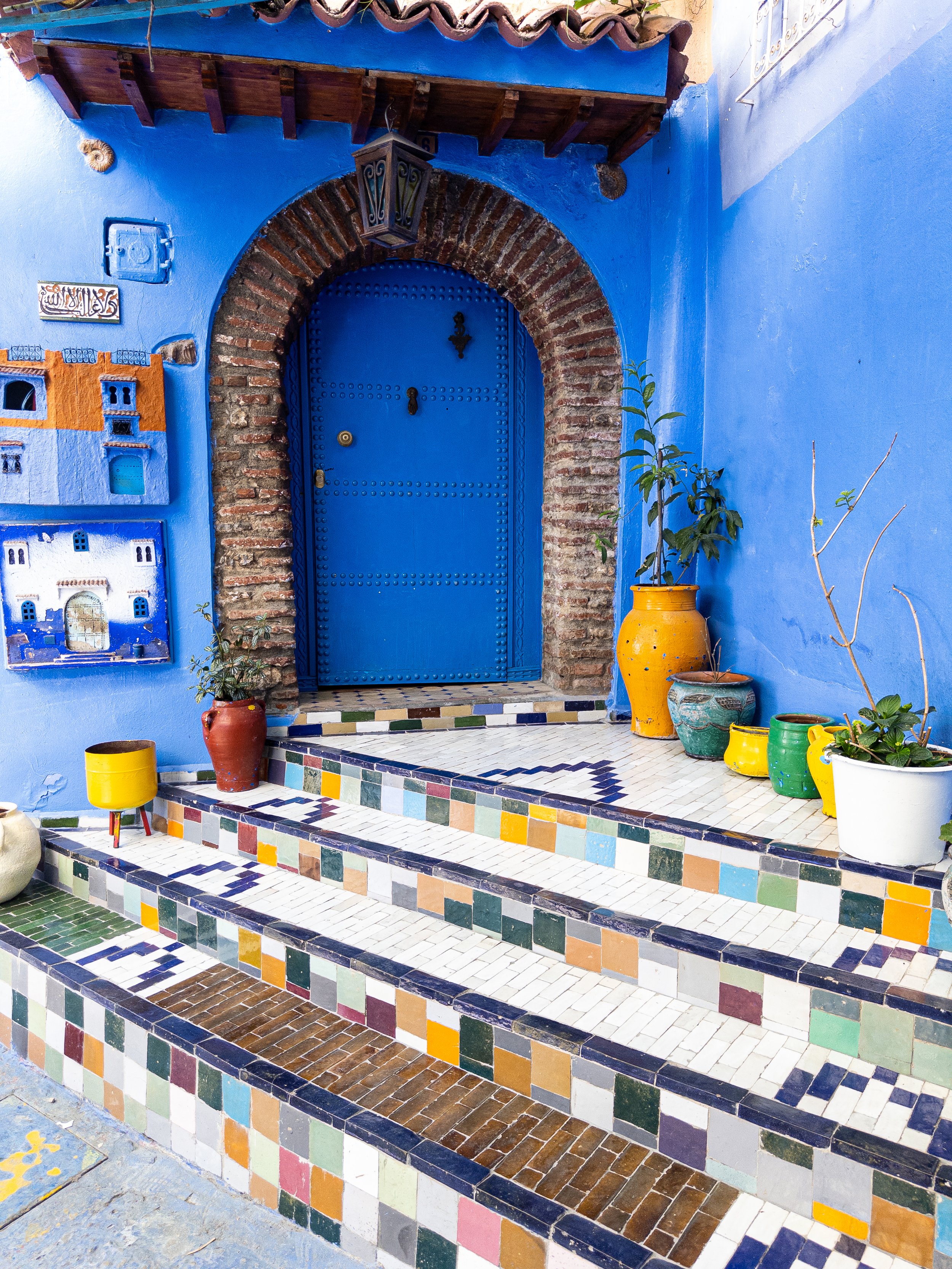 Blue arched doorway and colorful tiled steps in Morocco.