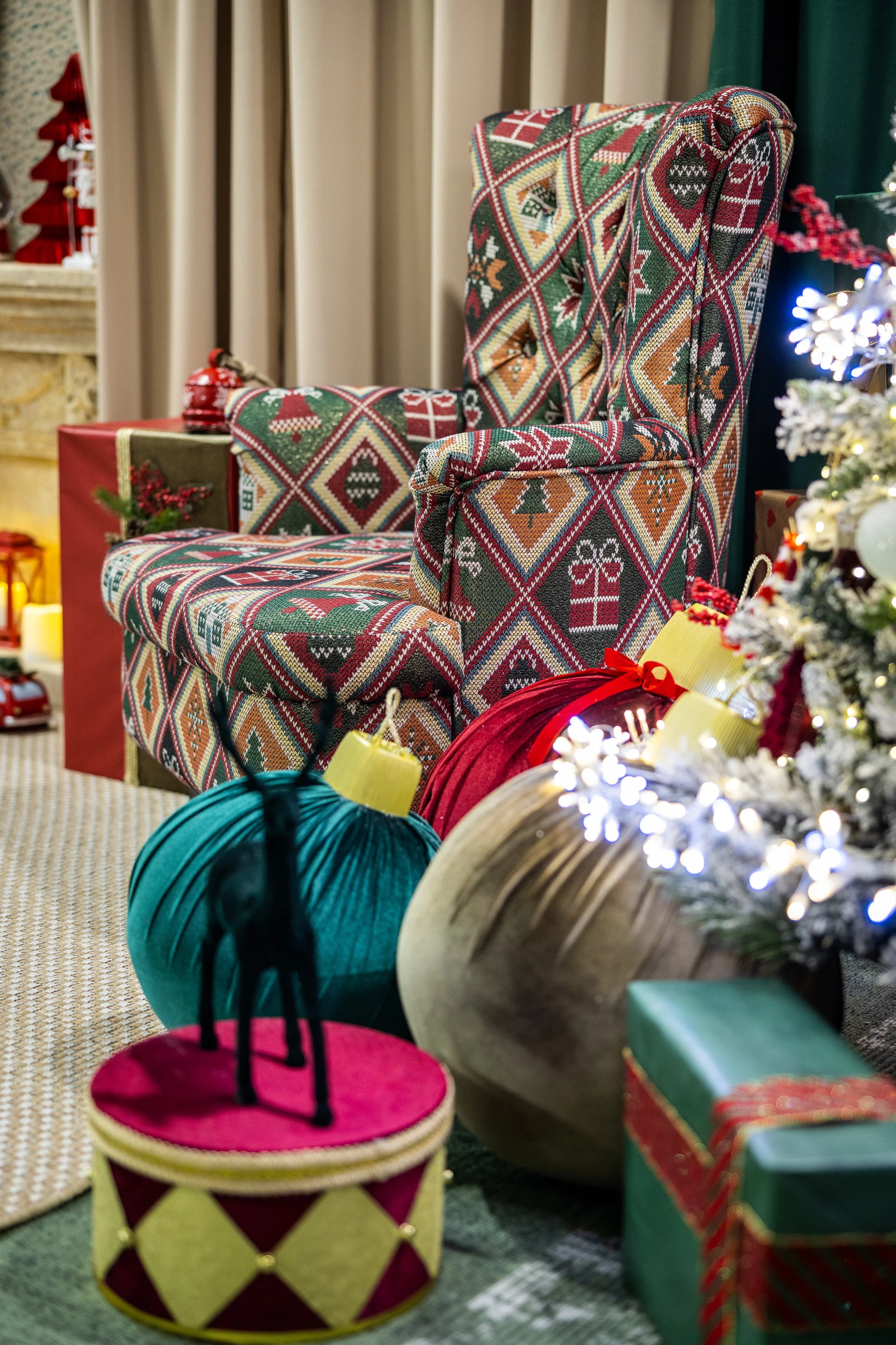 A decorated Christmas scene featuring wrapped presents, a Christmas chair with festive fabric, and holiday decorations including a Christmas tree with lights and ornaments.
