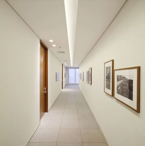 Na circulação das salas, um único rasgo define o ambiente.
Grupos de pontos de luz assinalam as portas de cada uma.