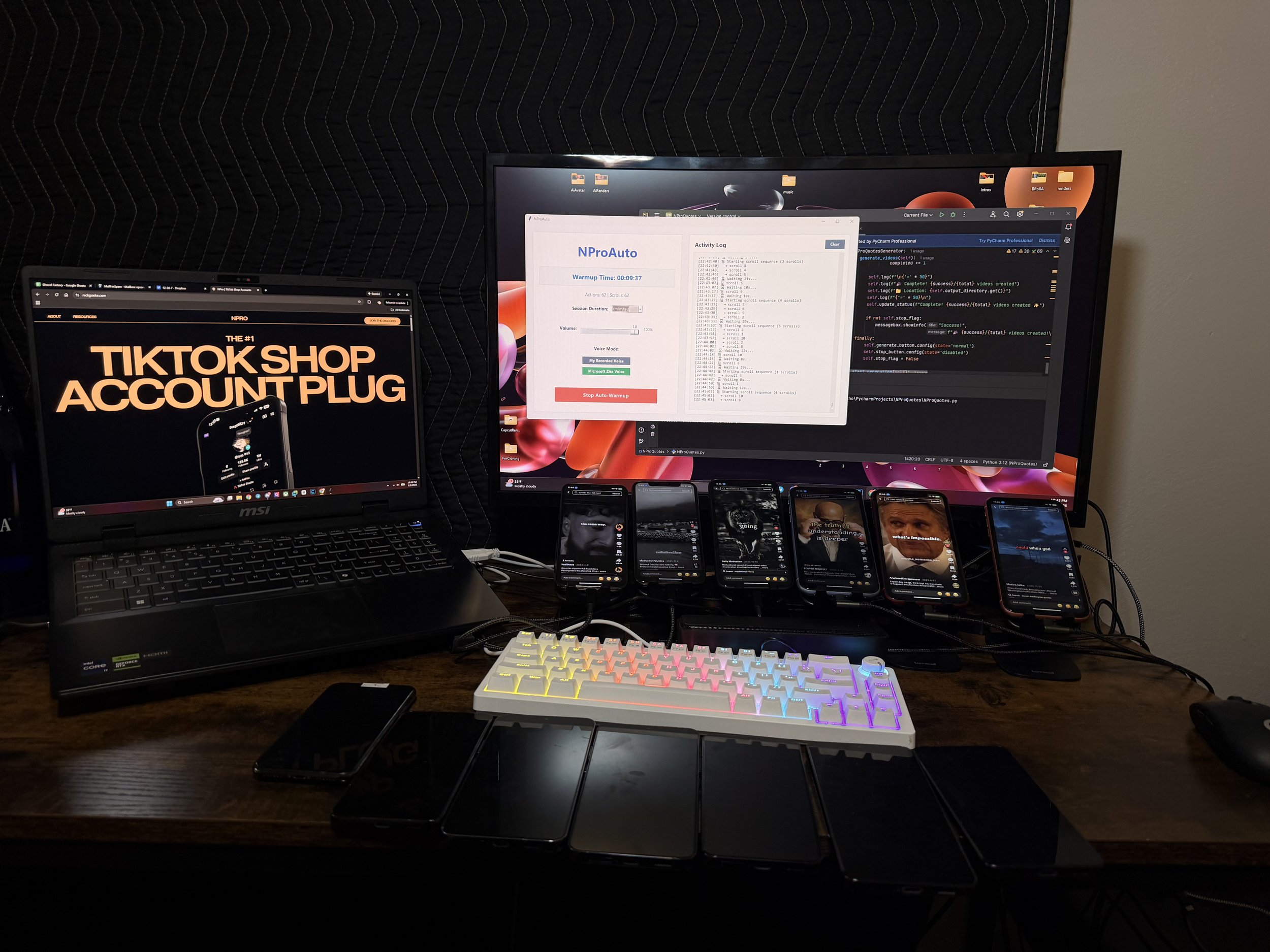 Multiple smartphones connected to a computer, a laptop, and a large monitor on a wooden desk, with a rainbow-colored keyboard and a mouse, in a dark room.