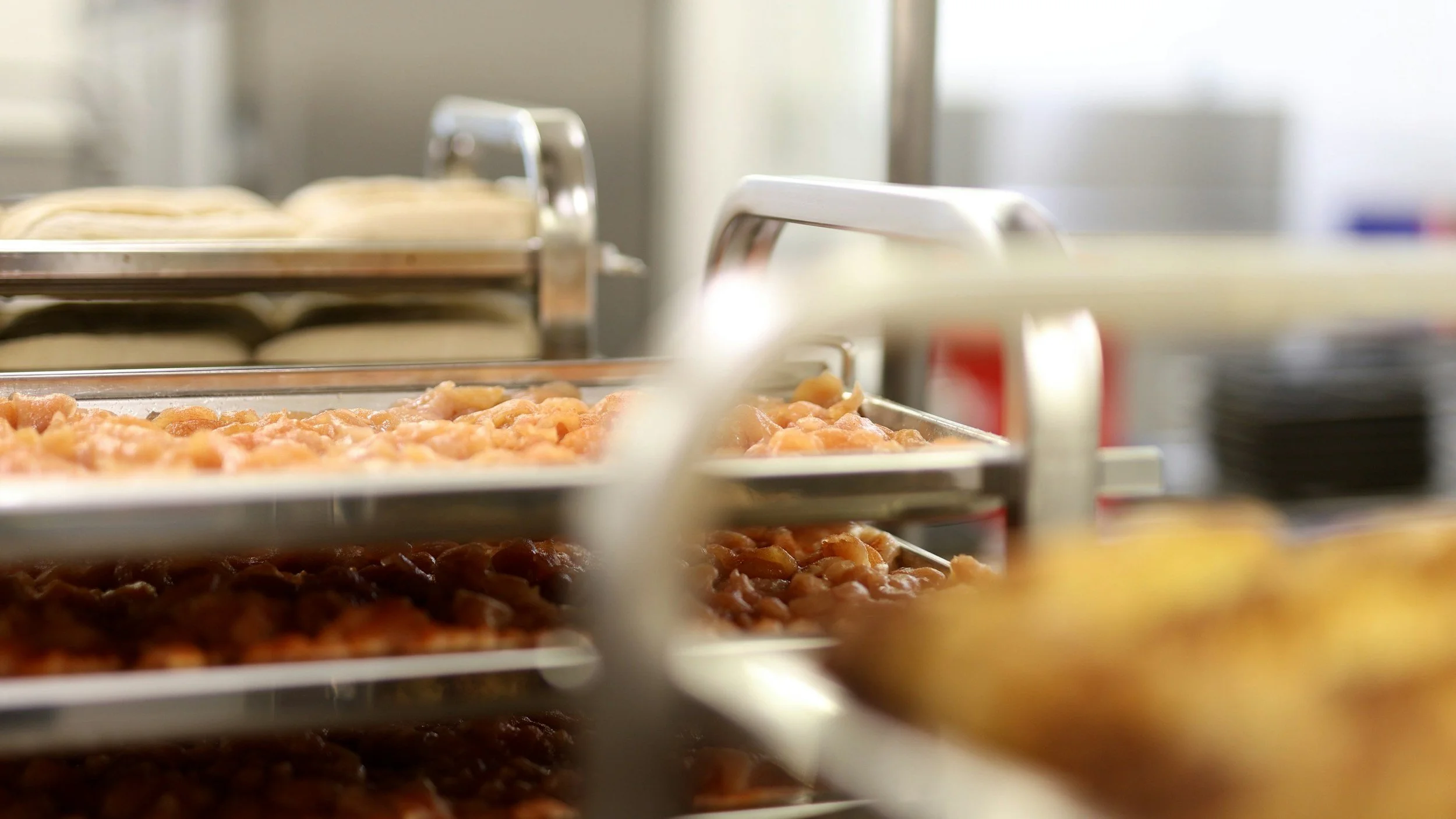 Close-up of trays of food on a processing rack in a commercial kitchen