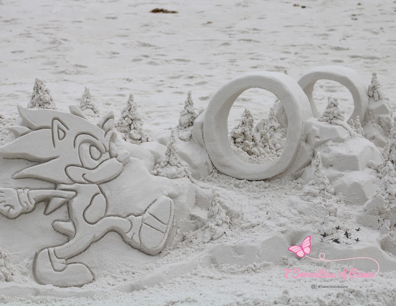 Sand sculpture of cartoon character with rings and trees