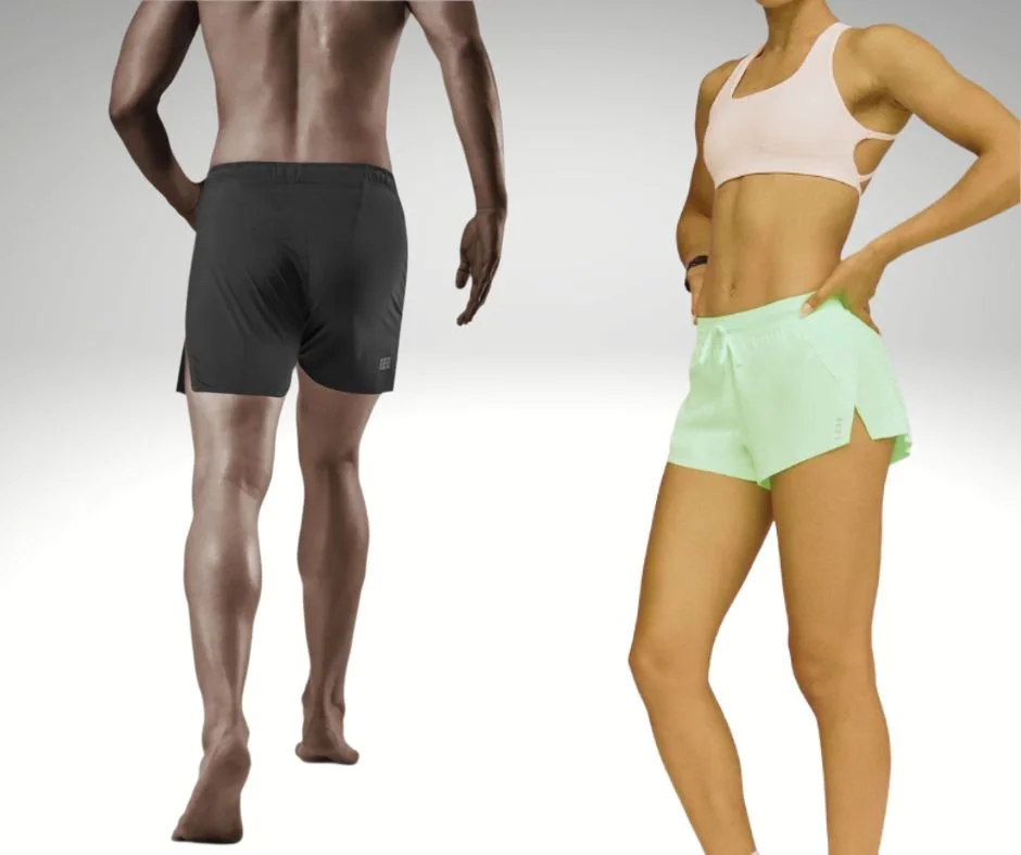 A man standing in black shorts with his back facing the camera and a woman standing in light green shorts with her hand on her hip, both dressed in athletic wear.