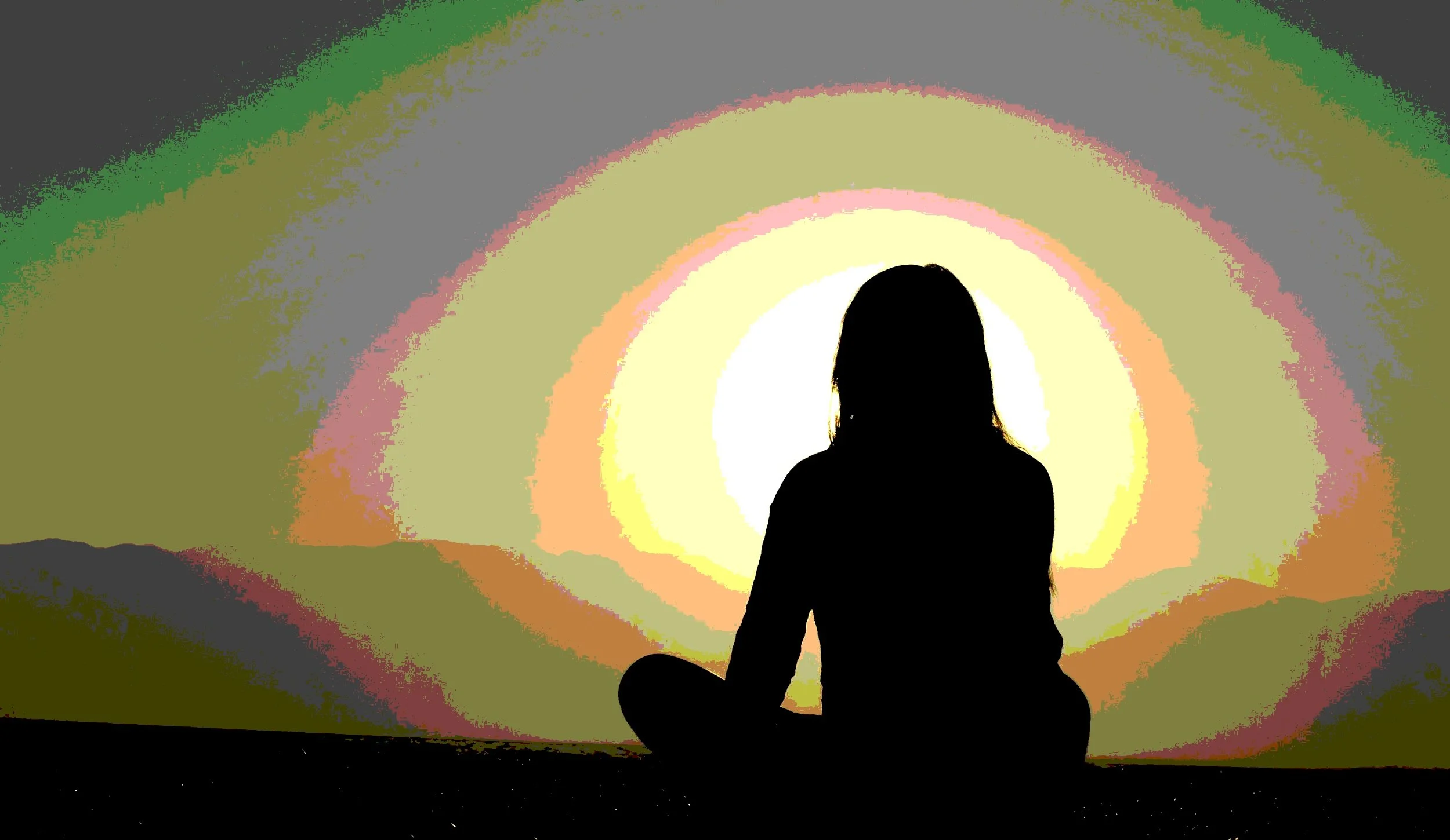 Silhouette of a girl sitting cross-legged in front of a colorful abstract background.