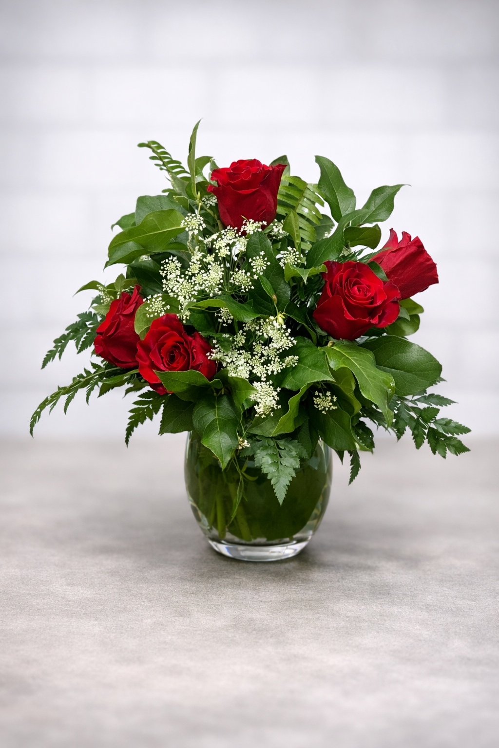 Elegant red rose bouquet in glass vase.png