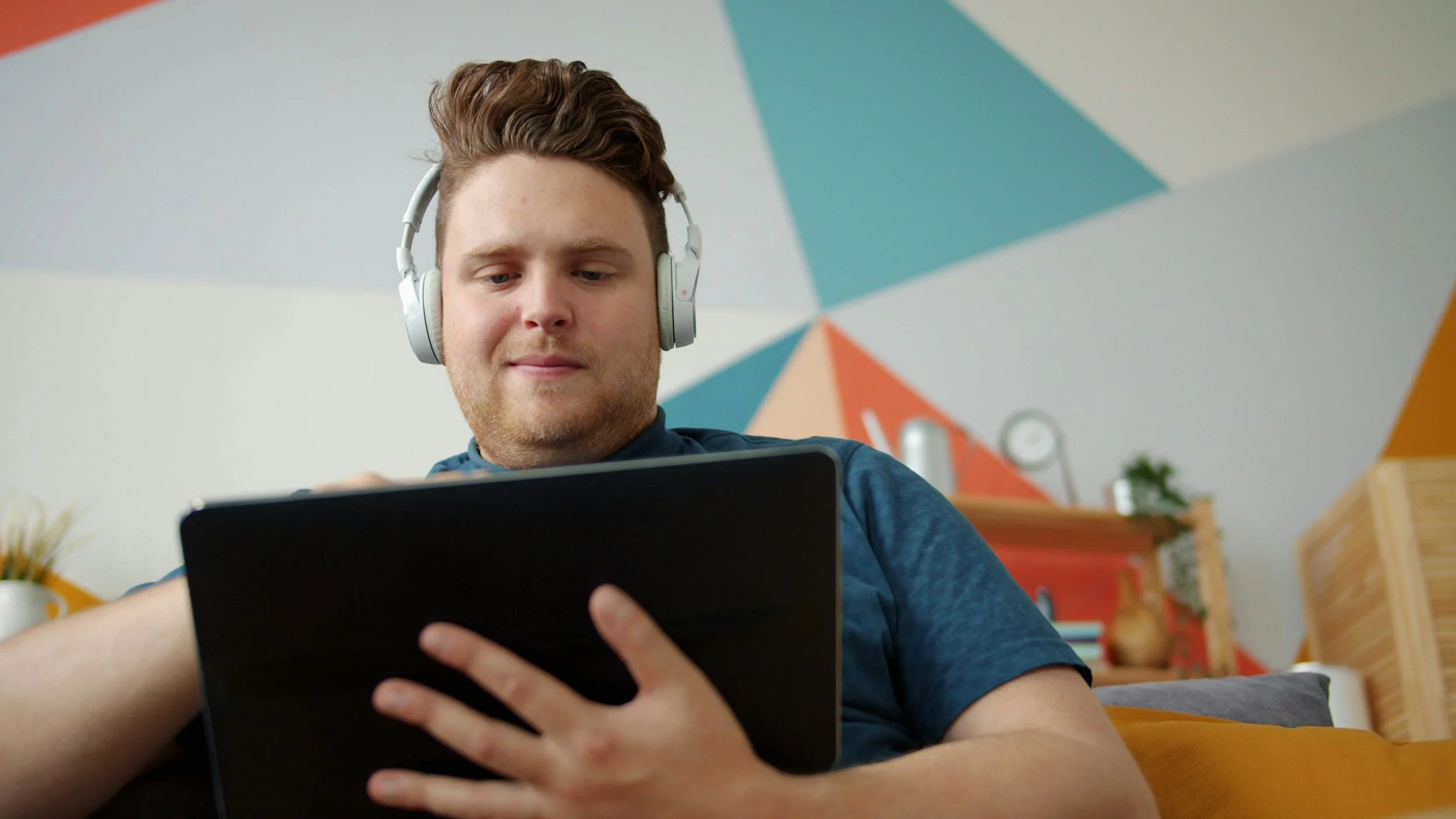 White man with headphones and ipad