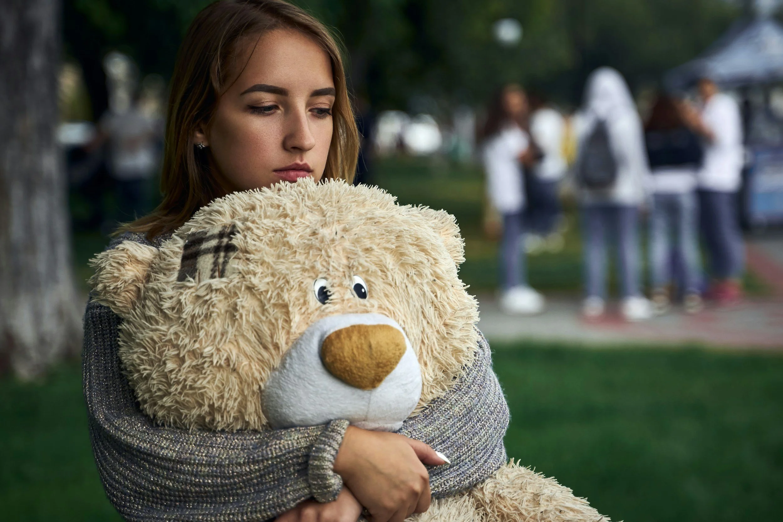 A young woman holding a teddy bear
