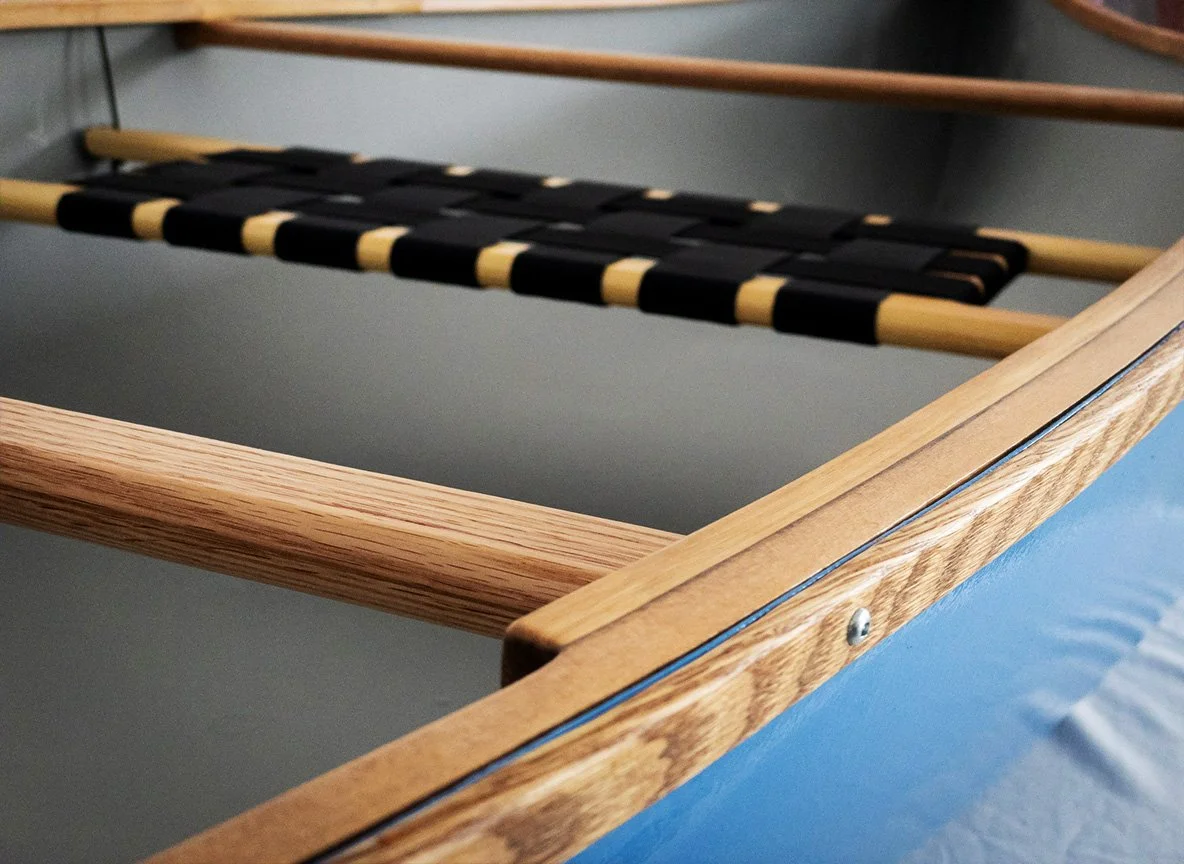 Detail shot of a canoe with wooden gunwales in natural oak finish