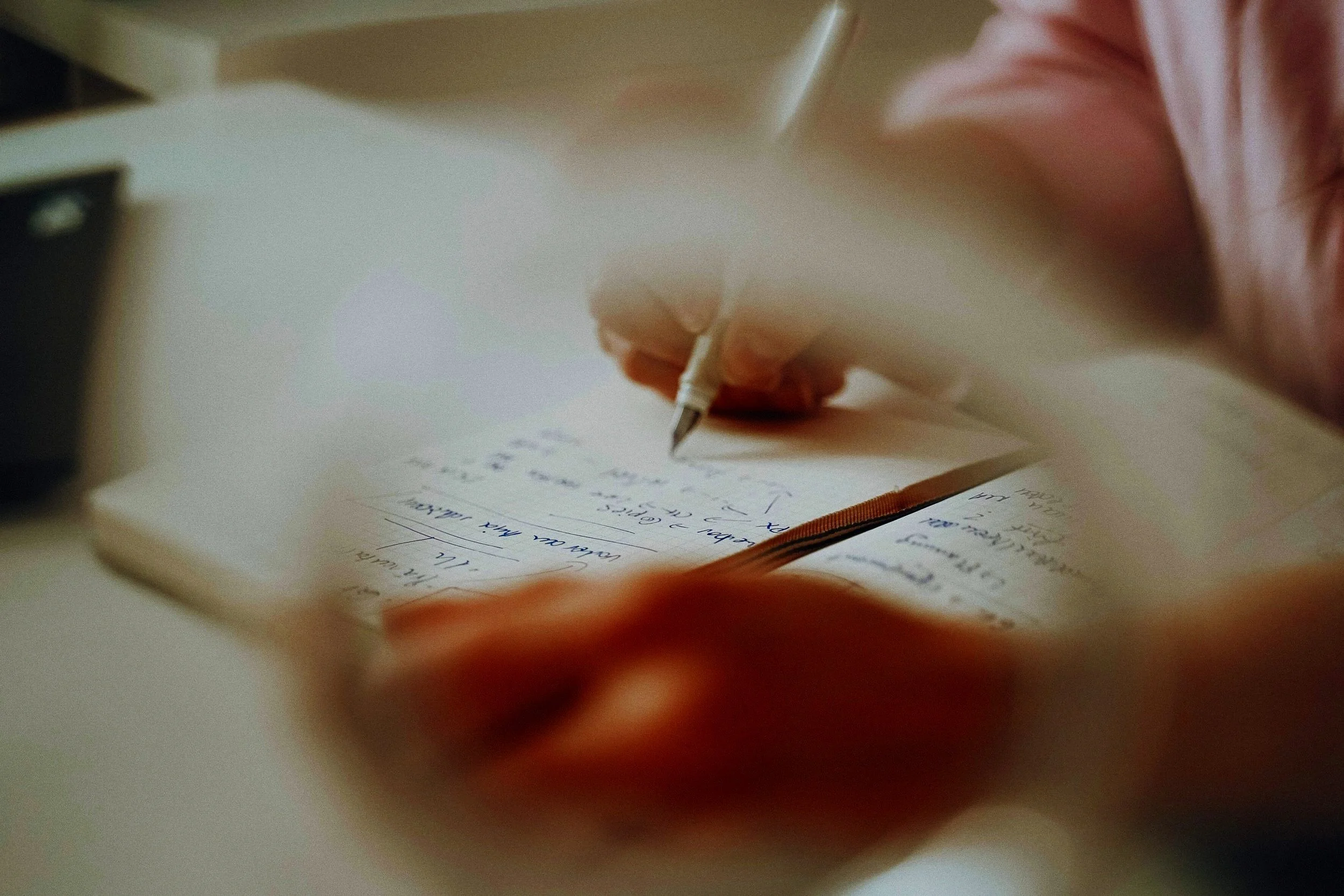 Im BIld zu sehen Rini Pegka mit Füller und Notizbuch