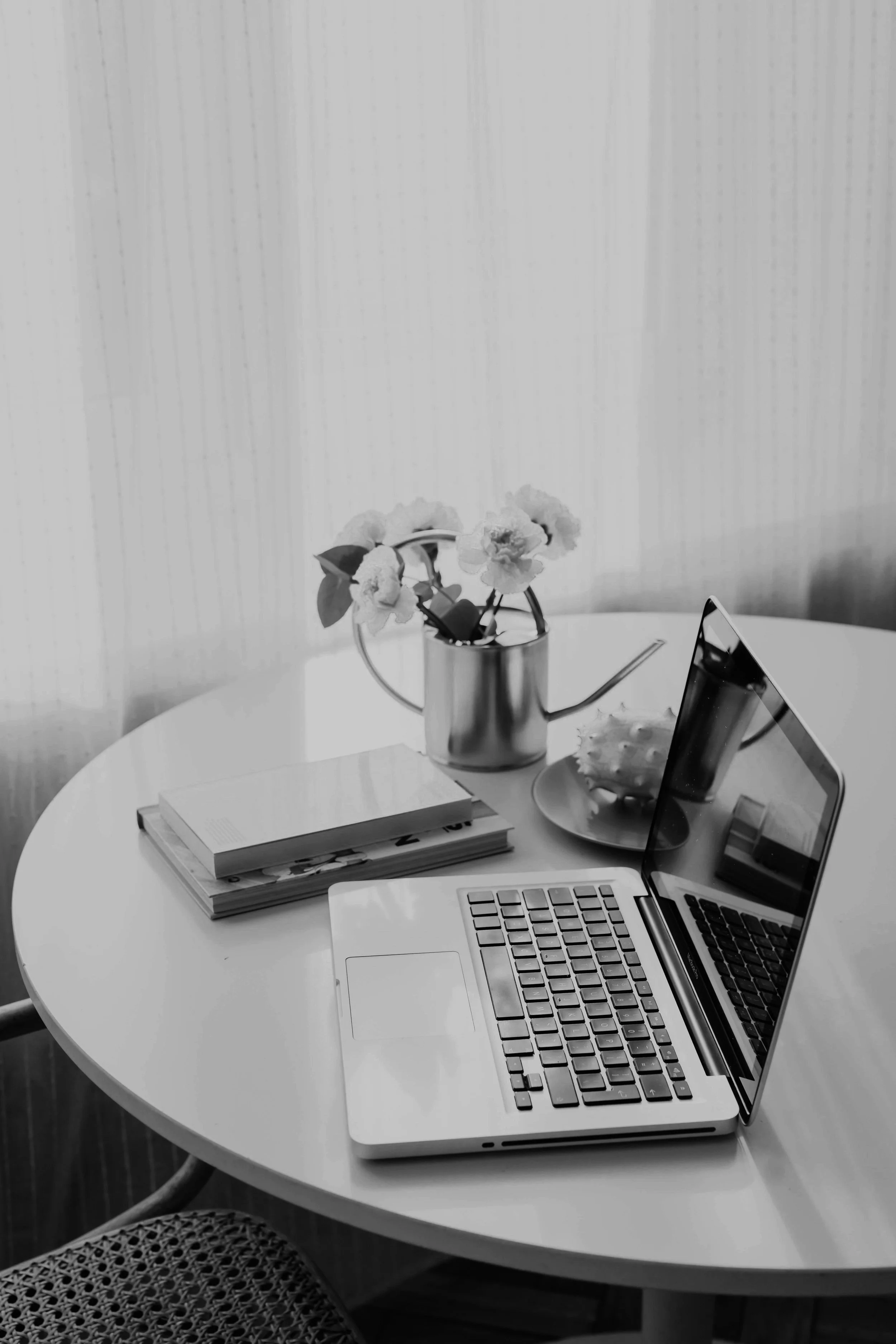 Schwarzweisses Bild mit offenem Laptop auf einem Tisch