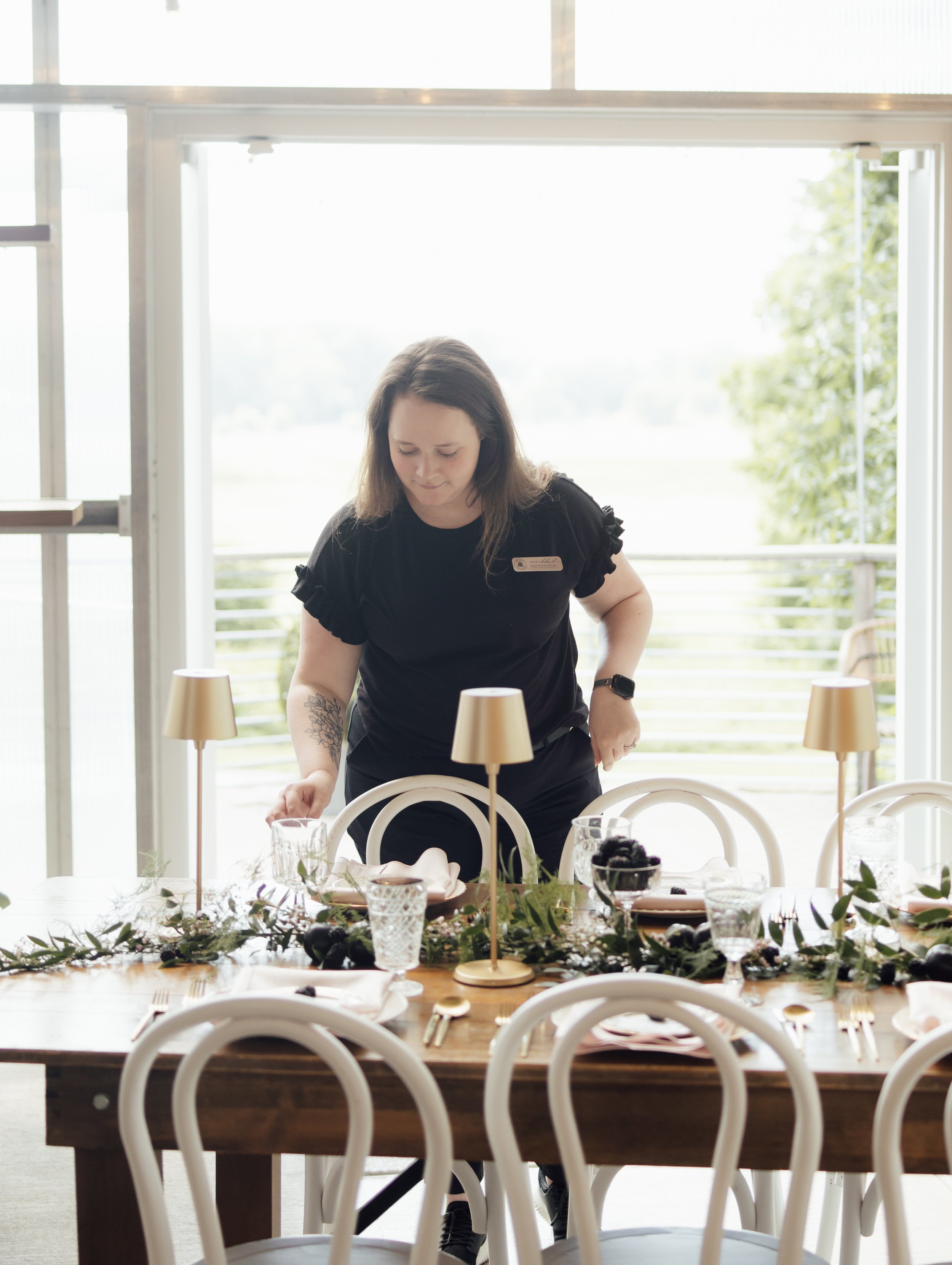 Wedding coordinator arranging tablescape at The Greenhouse at Bittersweet