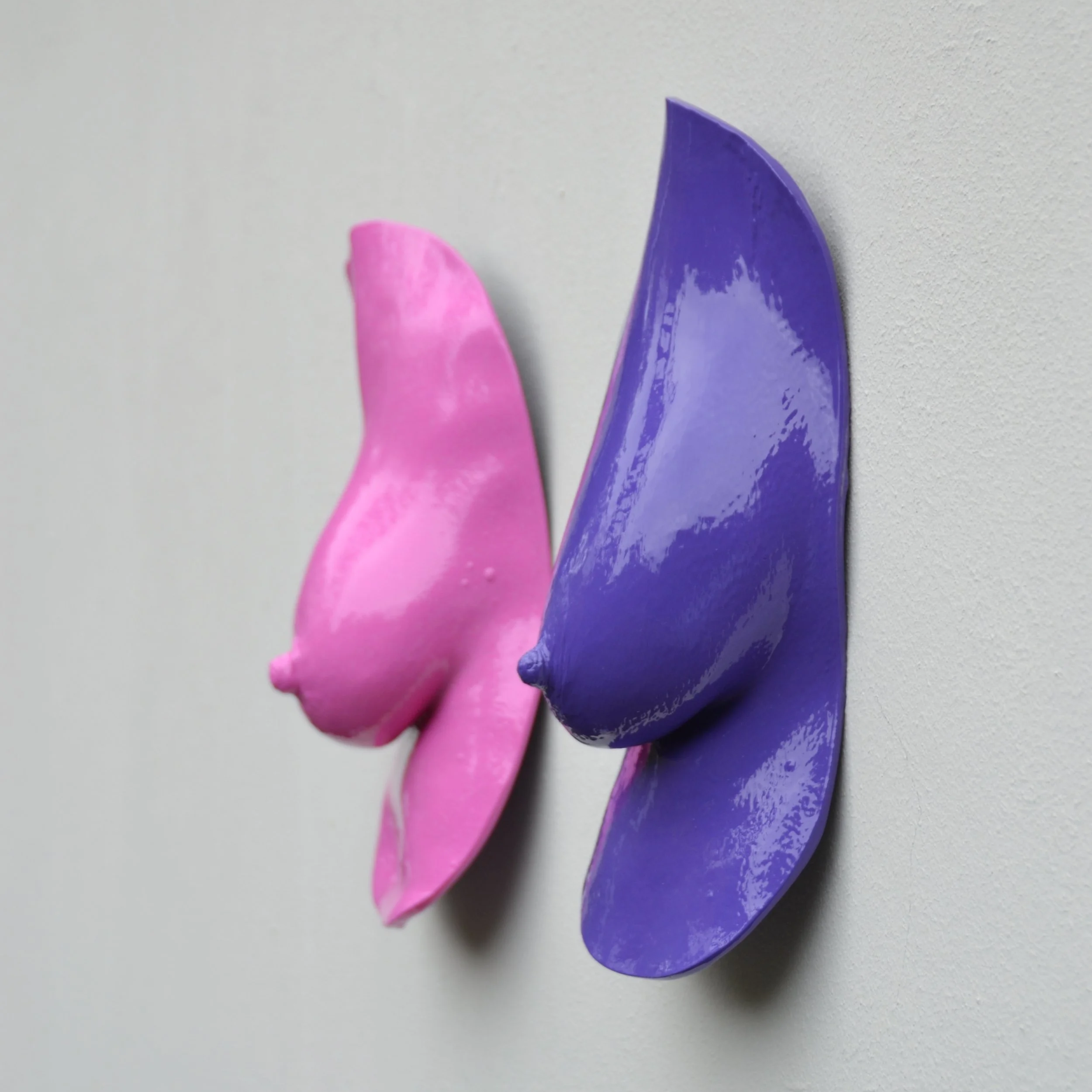 Handgemaakte borstsculpturen ter ere van borstvoeding in roze en paars, gevormd naar echte lichamen. Unieke lichaamskunst over diversiteit en lichaamsacceptatie.