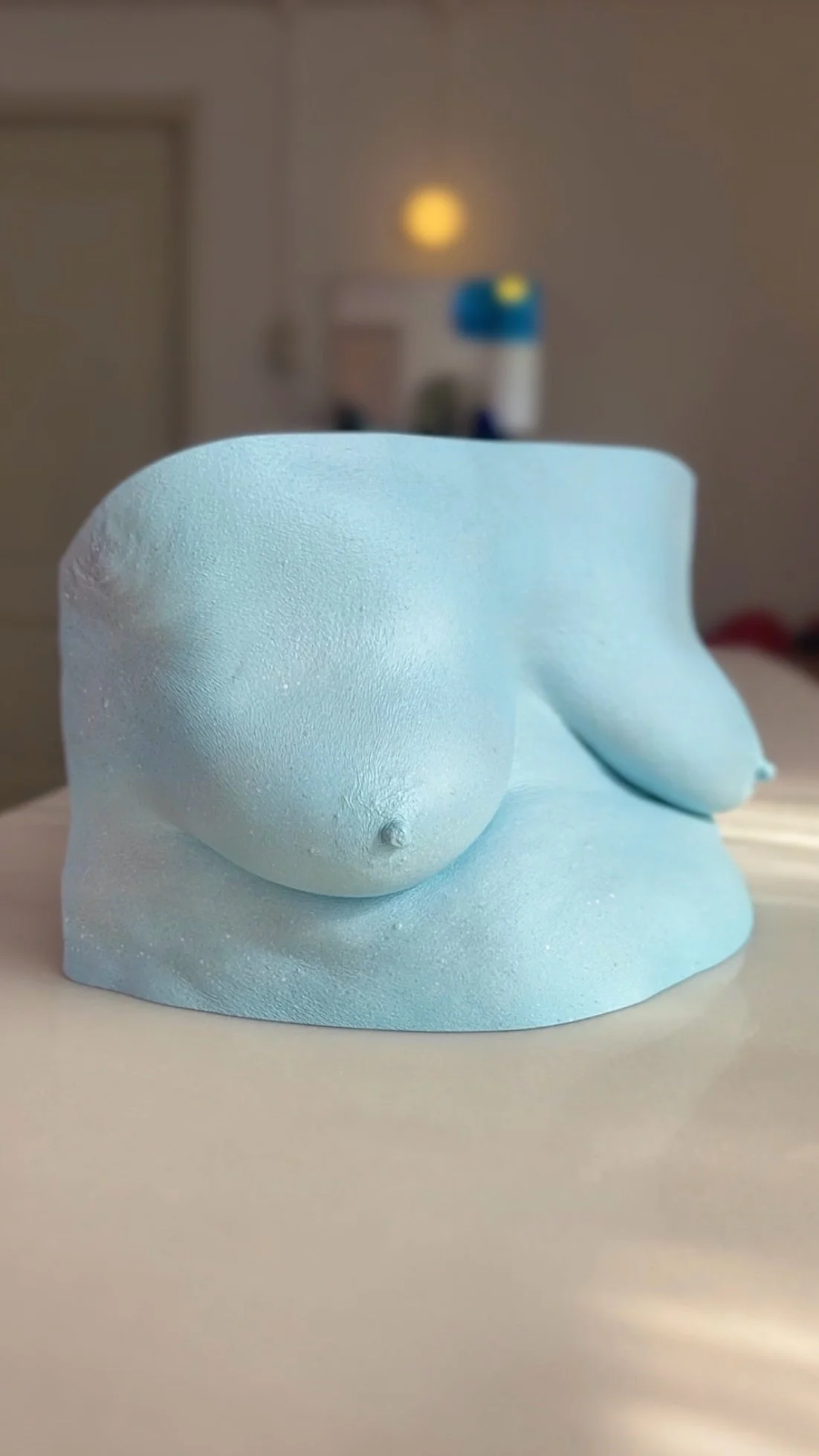 Lichtblauwe bodycasting borstsculptuur met steeneffect afwerking, handgemaakt van hars, kunstwerk van Venus in Vorm, gefotografeerd in het bodycasting atelier.