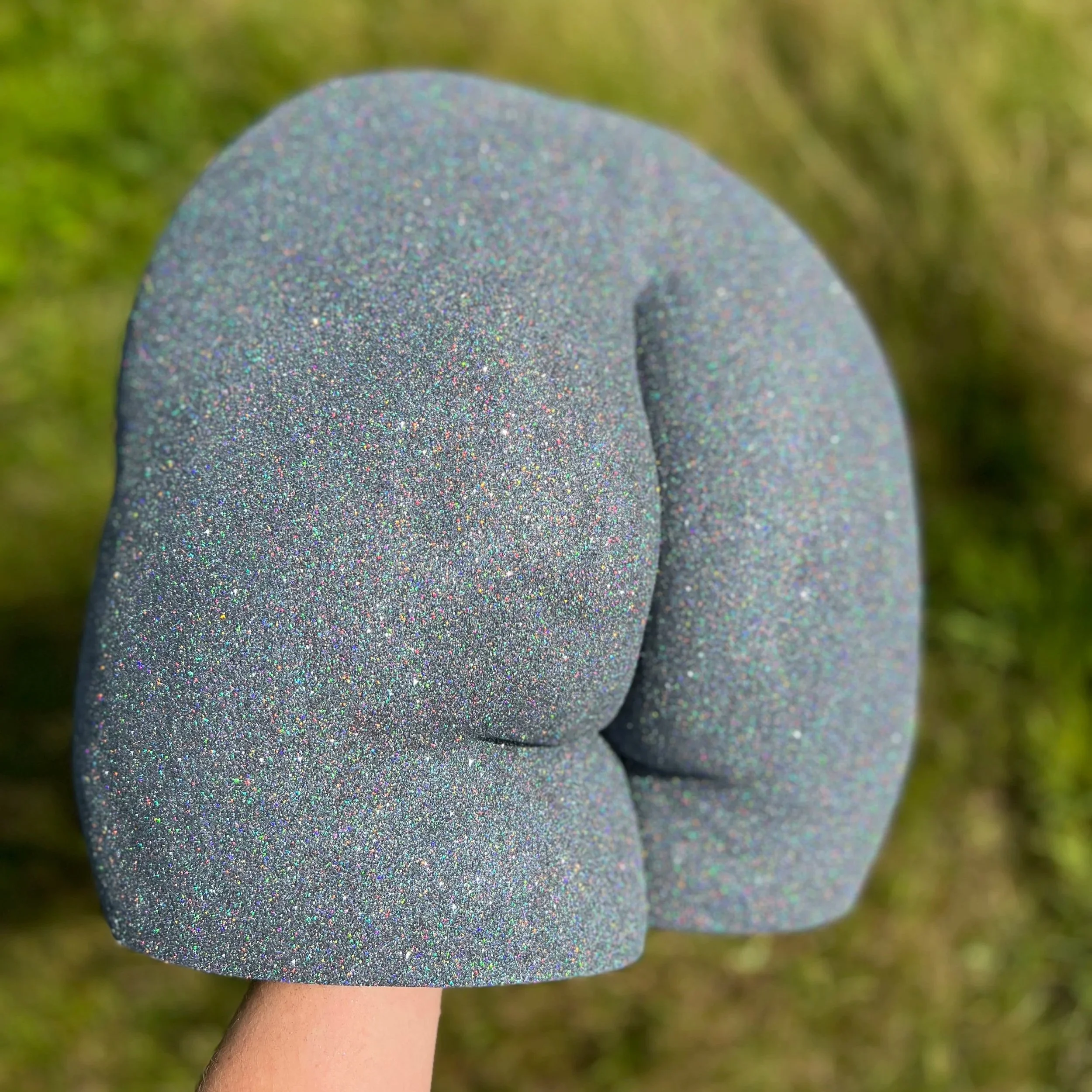 Bodycasting billensculptuur met Black Galaxy glitters, handgemaakt van hars met glanzende afwerking, kunstwerk van Venus in Vorm, gefotografeerd buiten in de zon met een grasveld op de achtergrond.