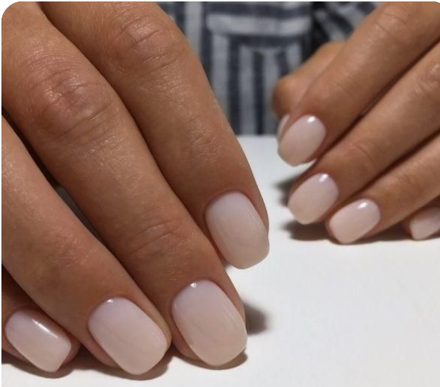 Close-up of natural gel manicure on a Polished Bermuda client, featuring short, rounded nails with a soft pink nude finish
