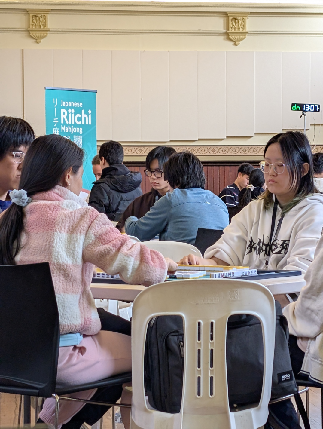 Mid-level shot of a table at Vic Riichi Open 2025 with the club banner in the background