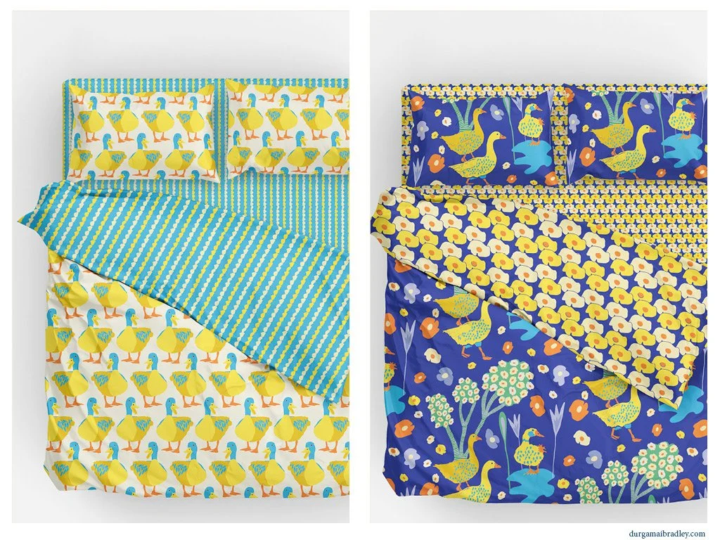 Two beds with duck-themed bedding. The left bed has a yellow ducks pattern with blue accents, the right bed has a navy background with yellow ducks and floral designs.