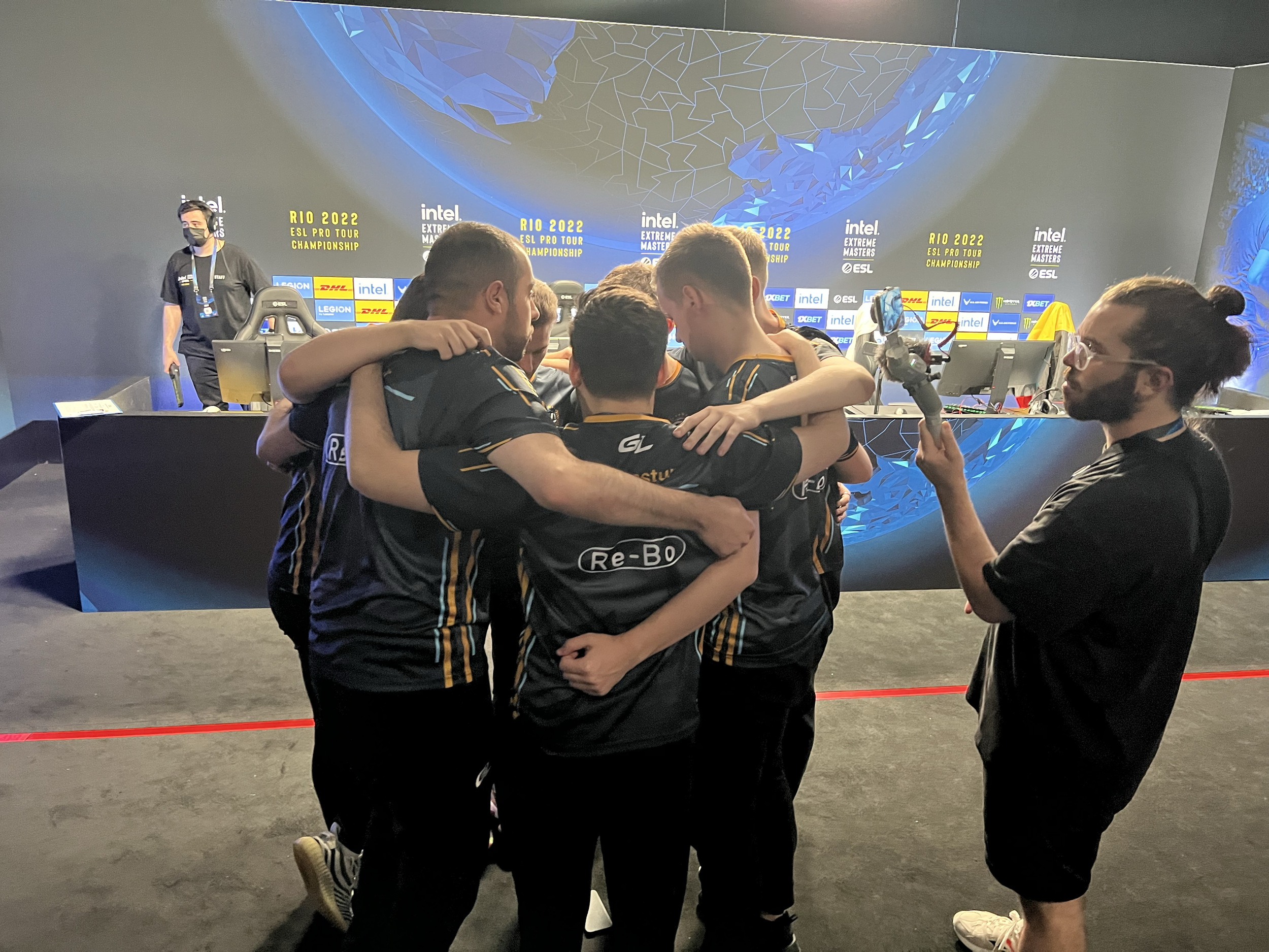 E-Sport Team umarmt sich vor Spiel auf Bühne, fotografiert bei einem Turnier