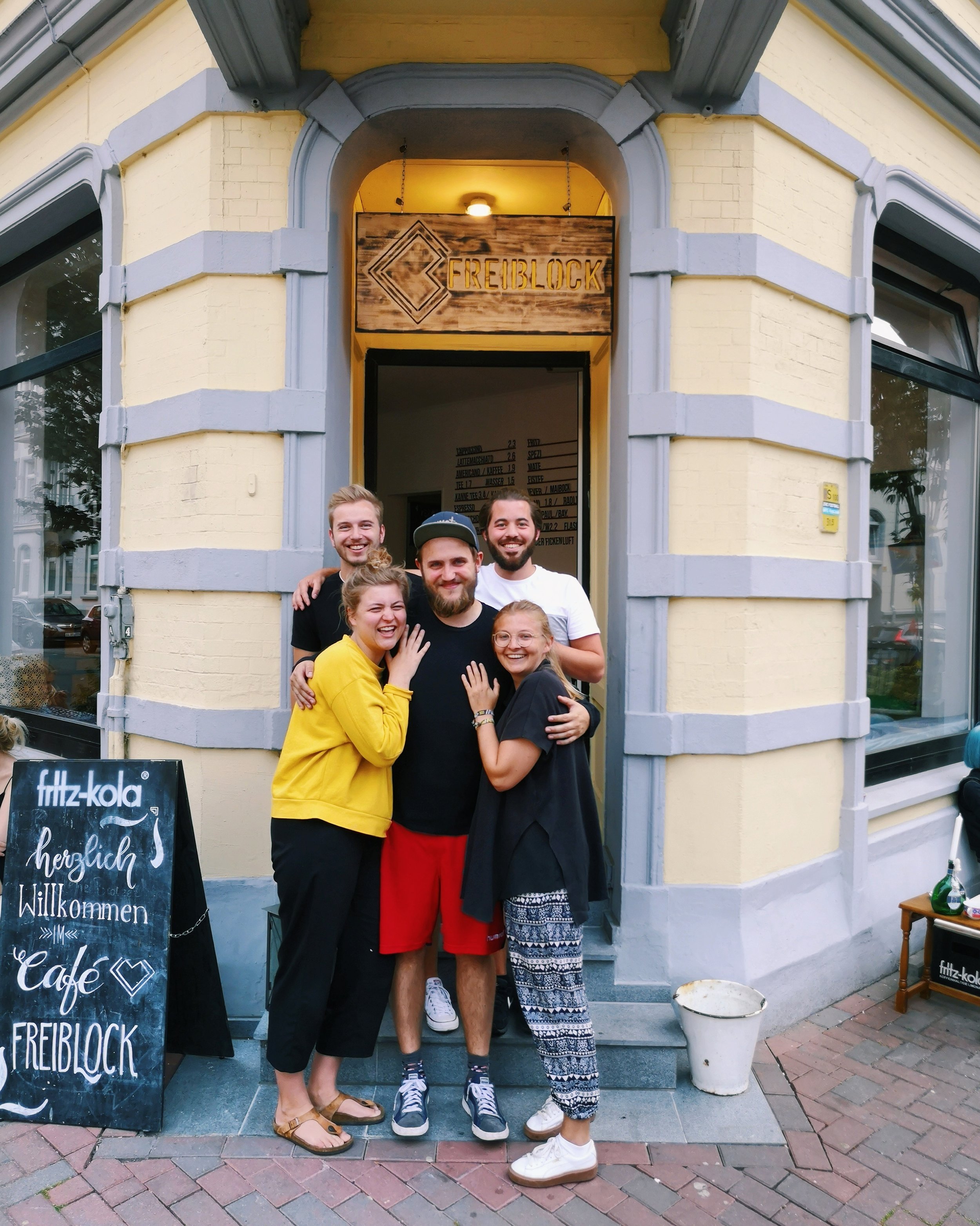 Teamfoto vor dem Eingang des Café Freiblock