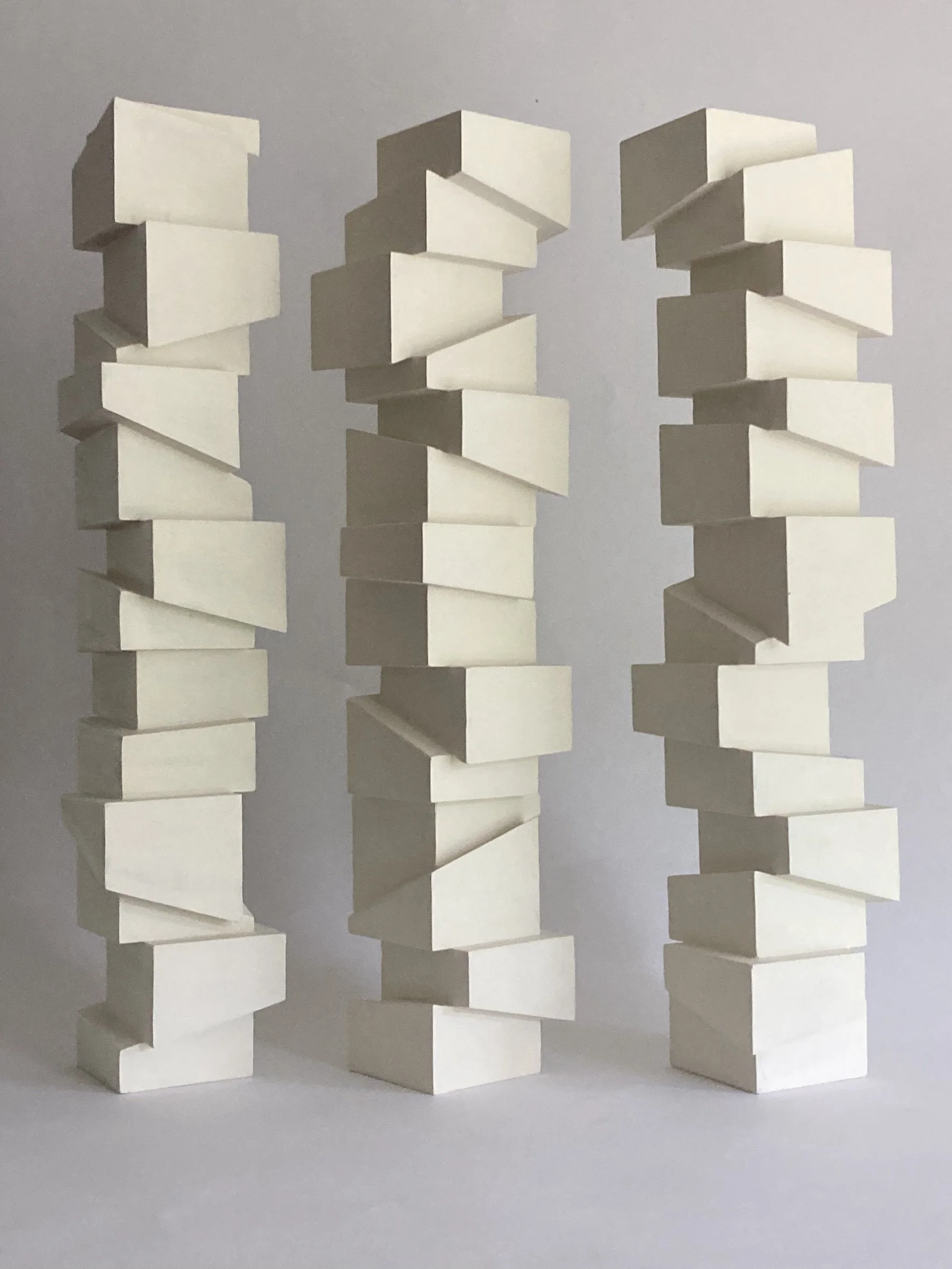 Slip Sculpture.  Vertical sculptures created by stacking cubes cut at angles.