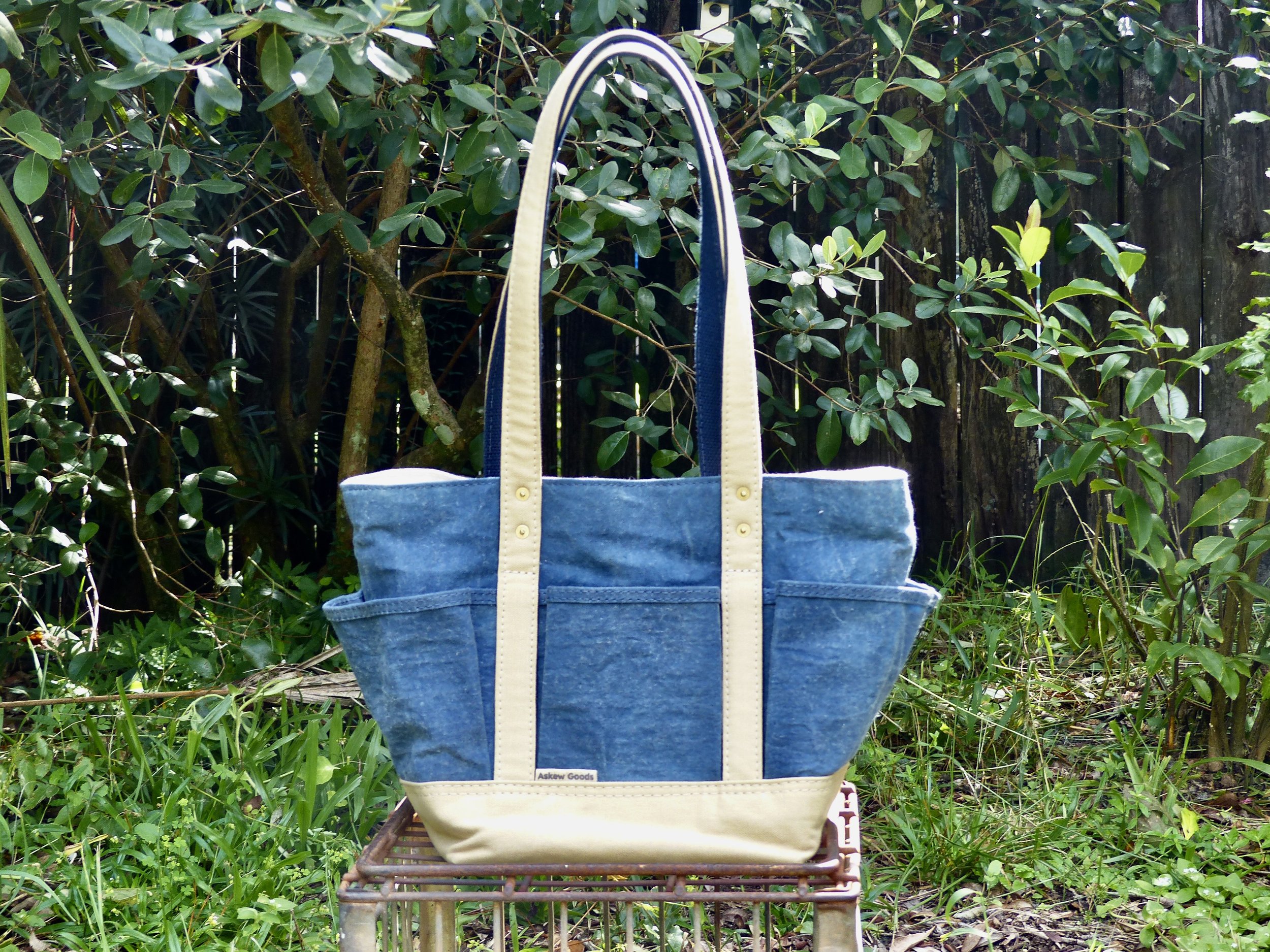 Hand-dyed indigo waxed with khaki straps and base.