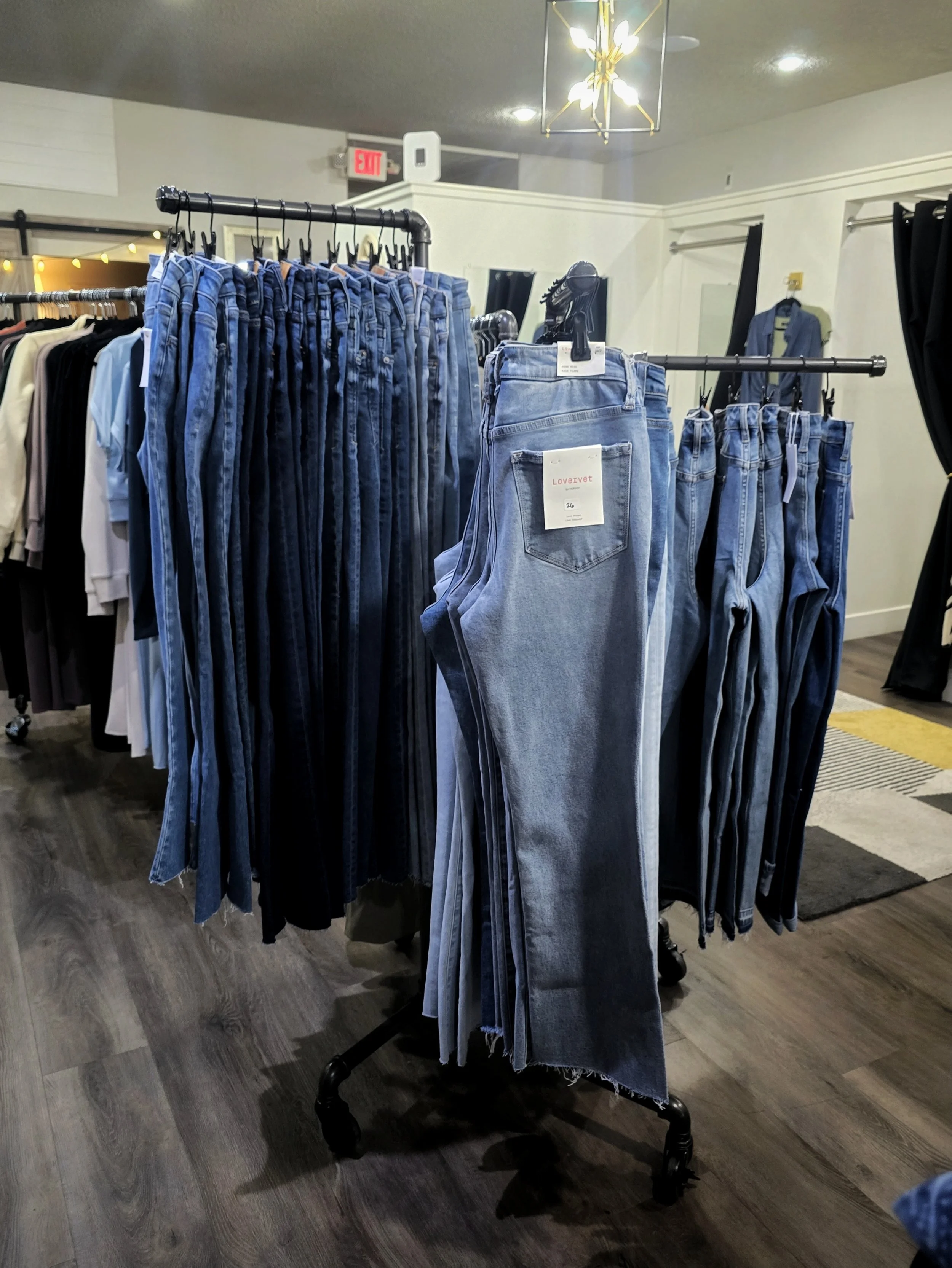 Display of blue jeans hanging on racks inside a clothing store.