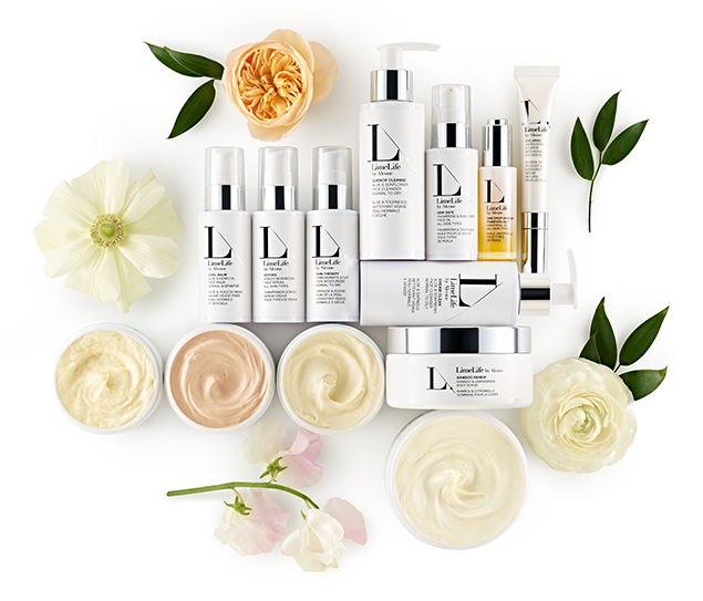 Collection of skincare products and flowers arranged on a white background.