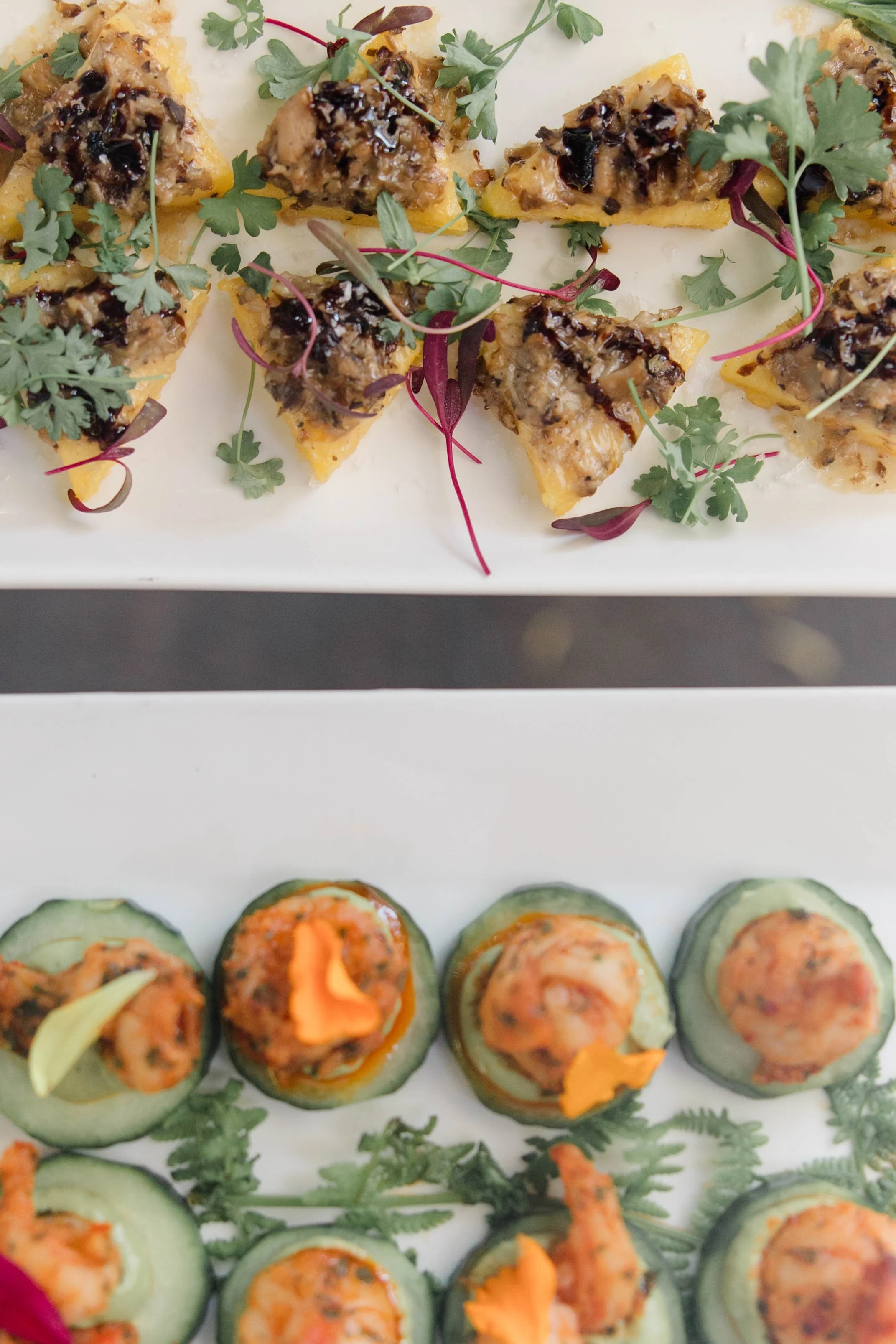 Appetizer plates with small tart-like snacks topped with herbs and garnishes.