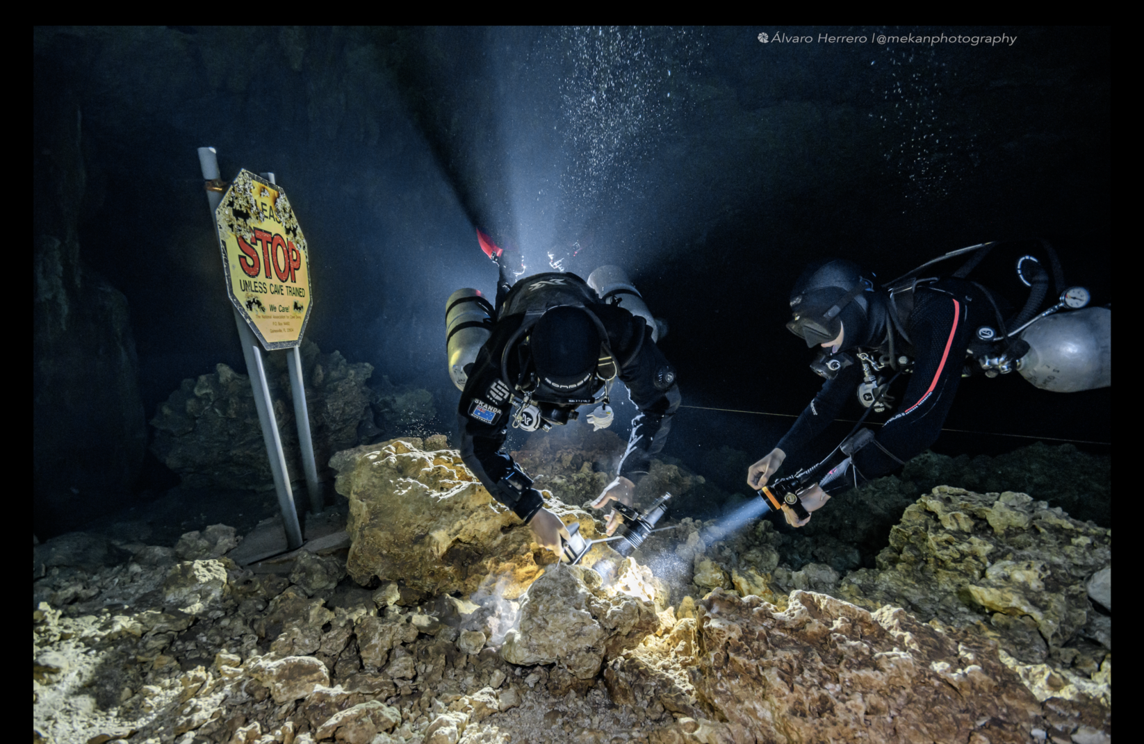 Skanda Coffield-Feith teaching a cave diving student using handheld light